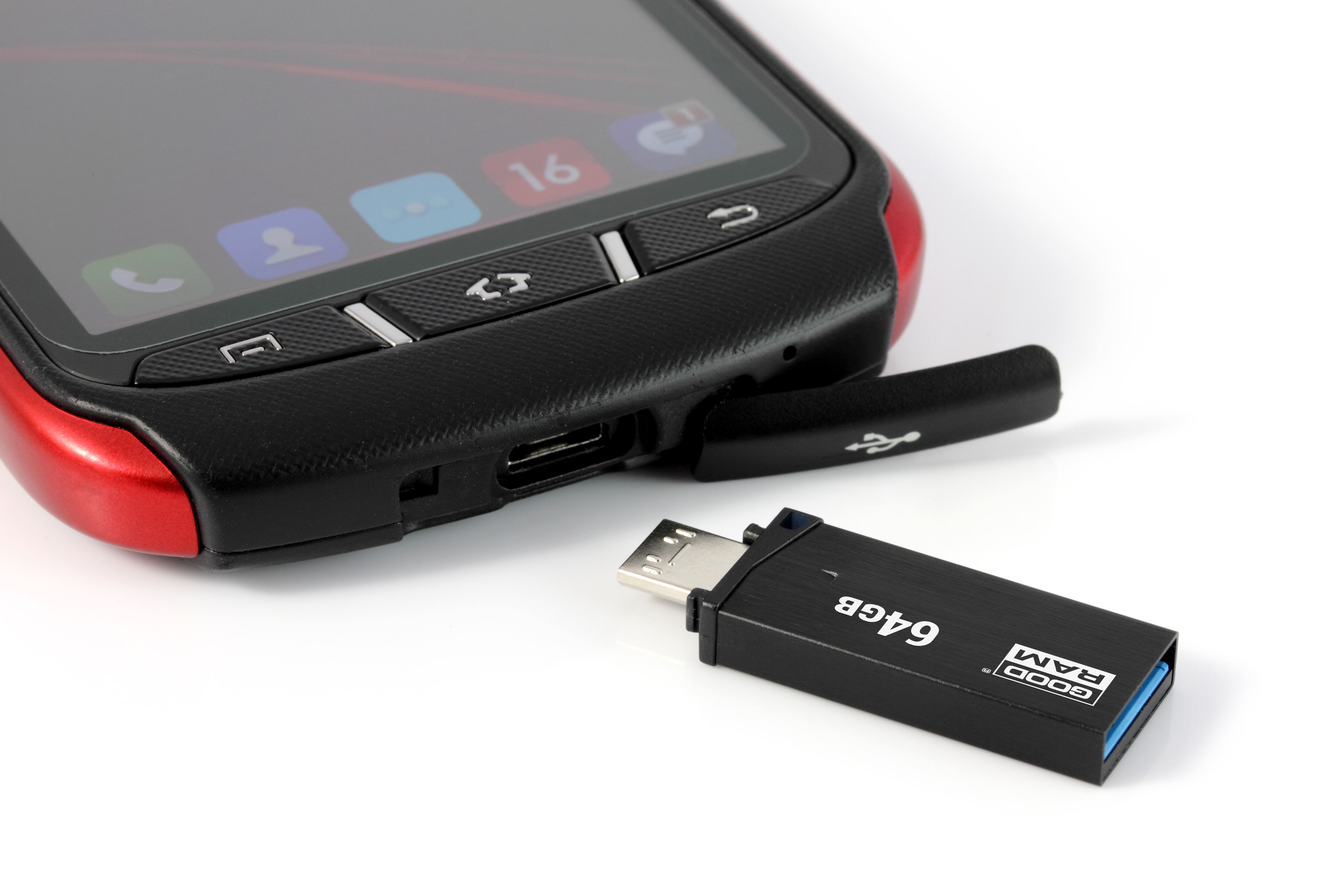 Chiavetta USB collegata a un telefono. Il telefono è rosso e nero. La chiavetta USB è nera e ha 64 GB.
