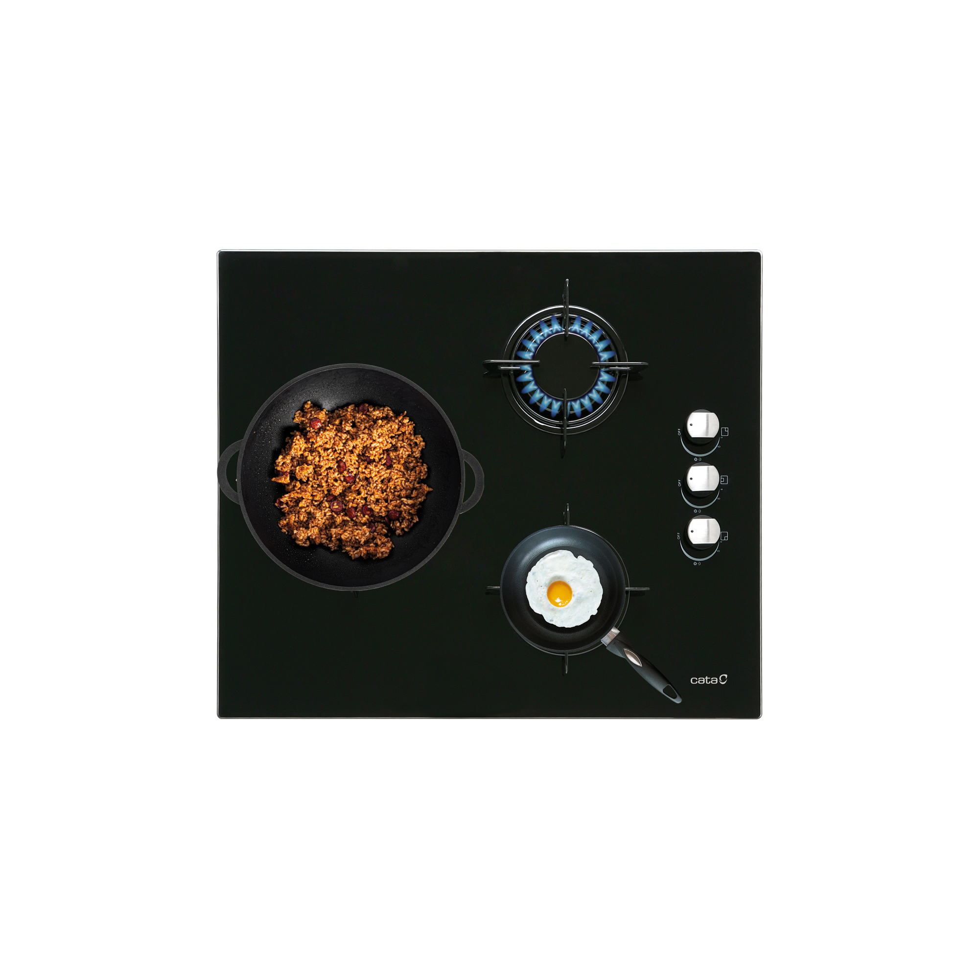 Widok z góry na czarną szklaną płytę grzejną z trzema palnikami: dwoma z jedzeniem i jednym z niebieskim płomieniem. Białe tło.