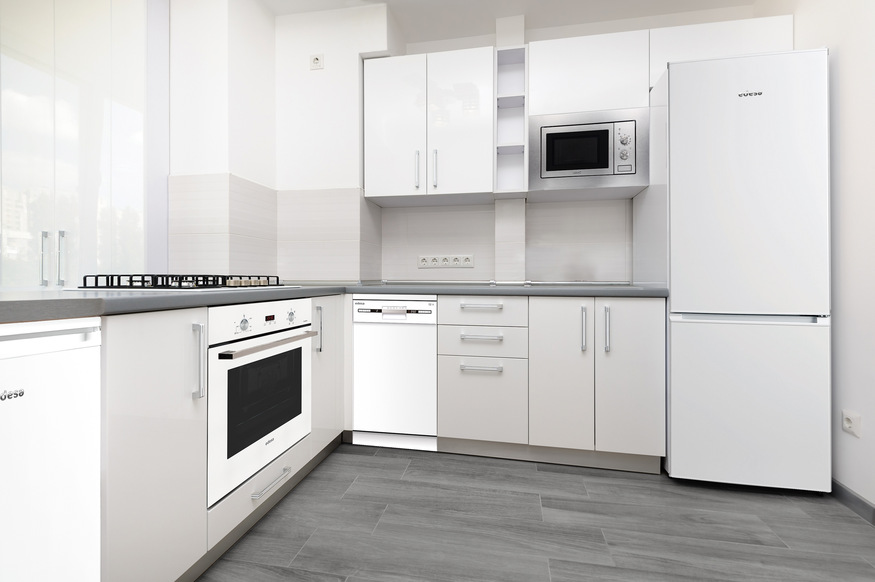 Cocina blanca moderna. Incluye gabinetes, horno, microondas y refrigerador. Piso gris.