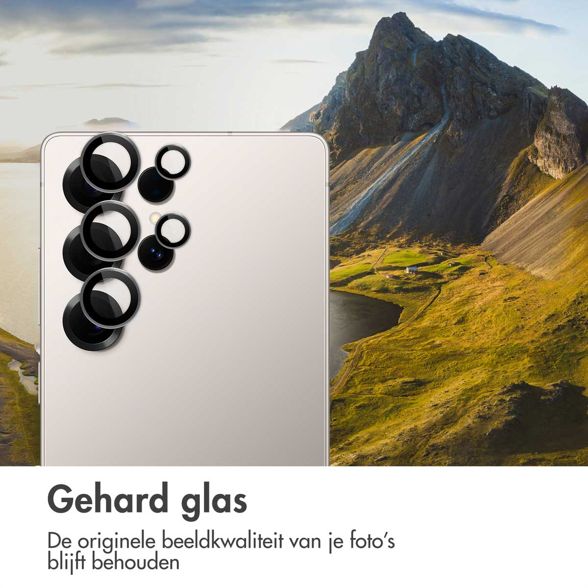 Een witte telefoon met zwarte cameralensafdekkingen tegen een berglandschap.