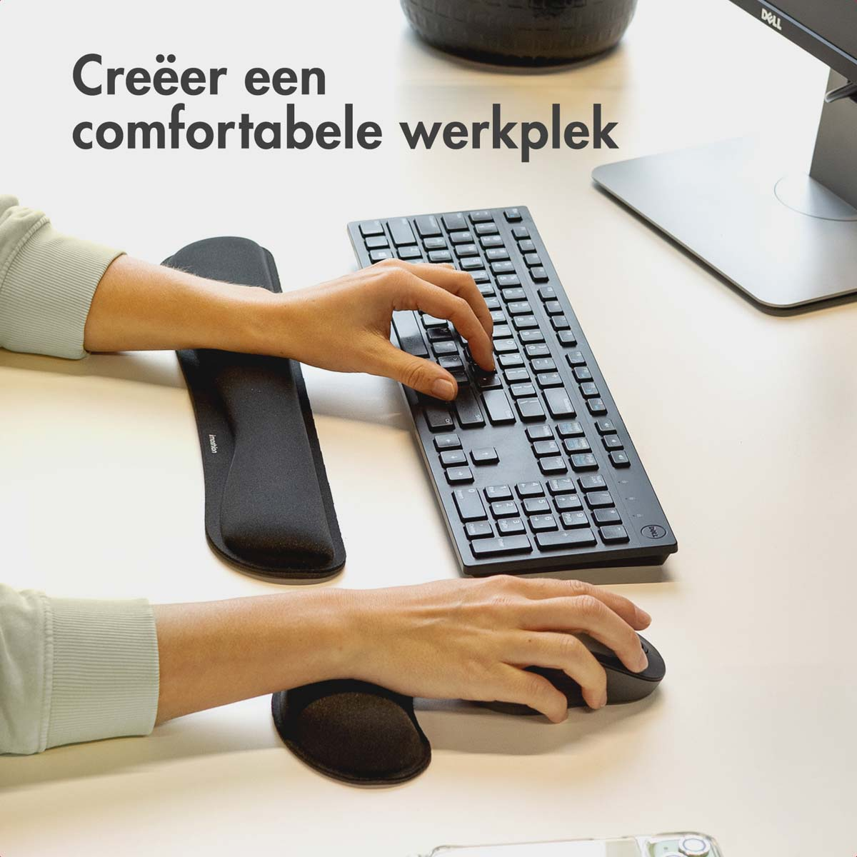 Hands using a keyboard and mouse with wrist rests. White desk with black accessories.