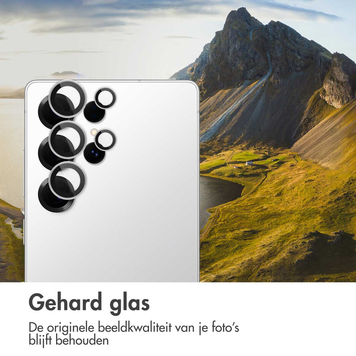 Een witte telefoon met zwarte cameralensafdekkingen tegen een berglandschap.