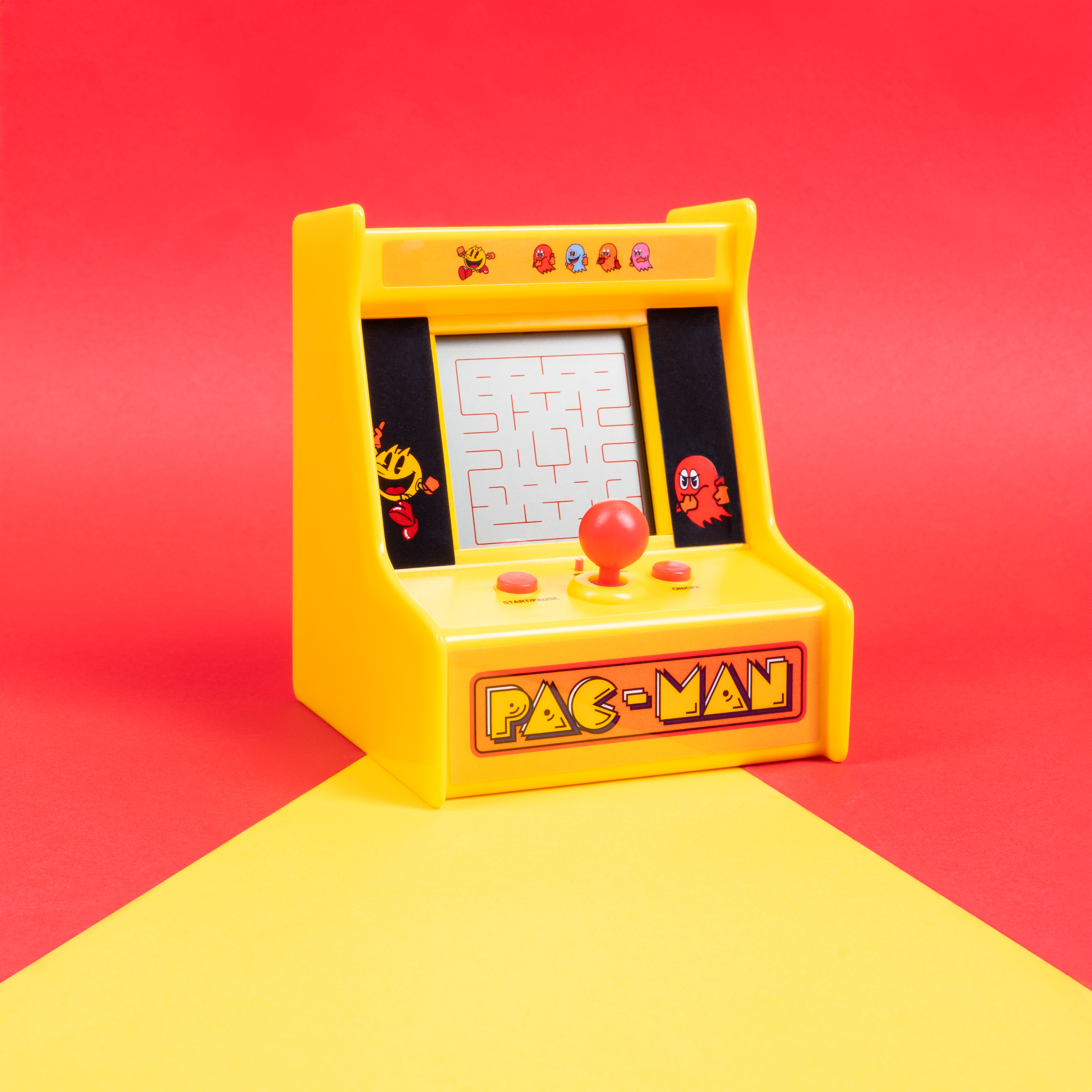 Gele Pac-Man arcade machine op een rode en gele achtergrond.