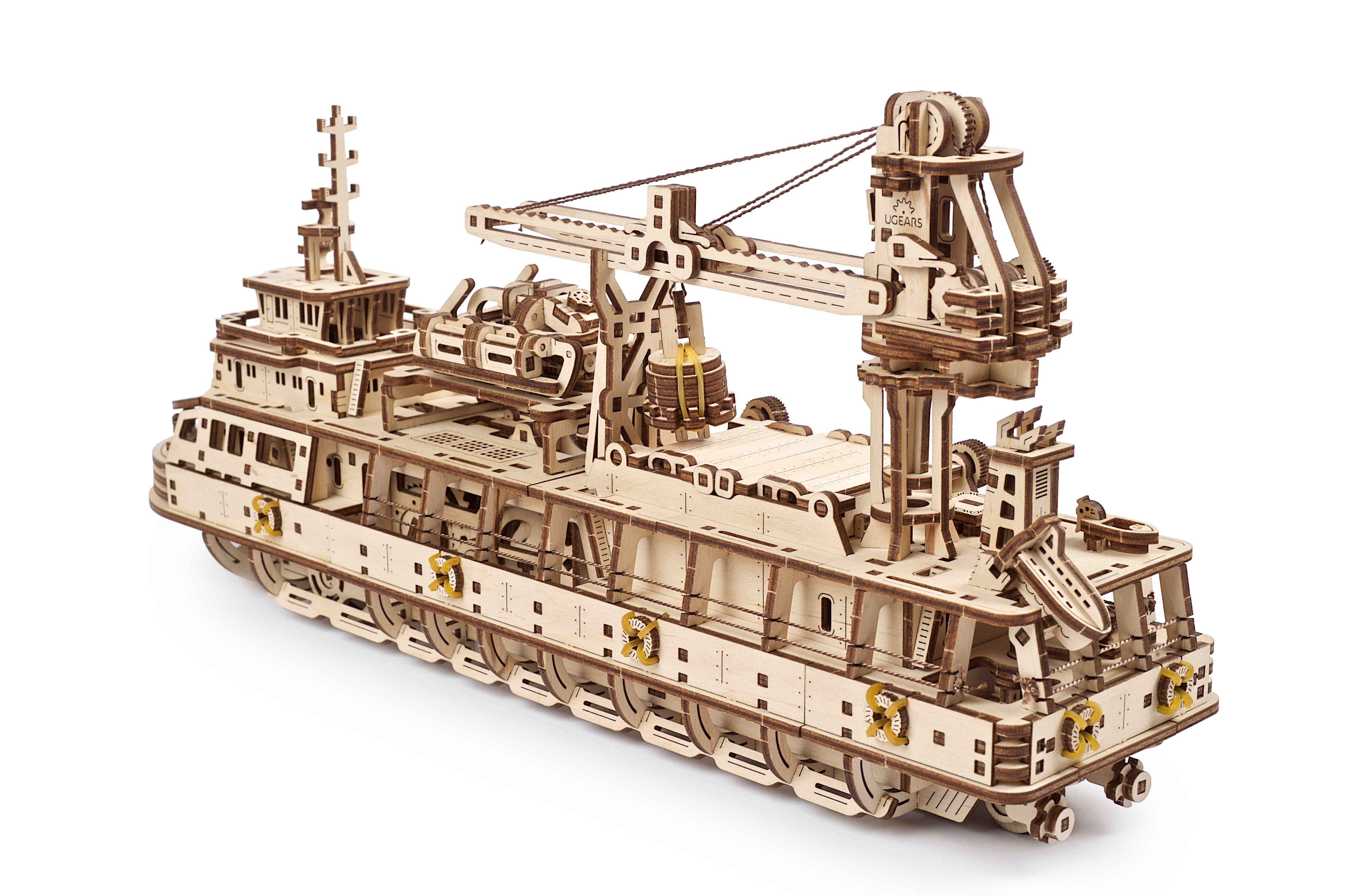 Drewniany model statku towarowego z żurawiem, kołami ratunkowymi i różnymi drewnianymi konstrukcjami, na białym tle.