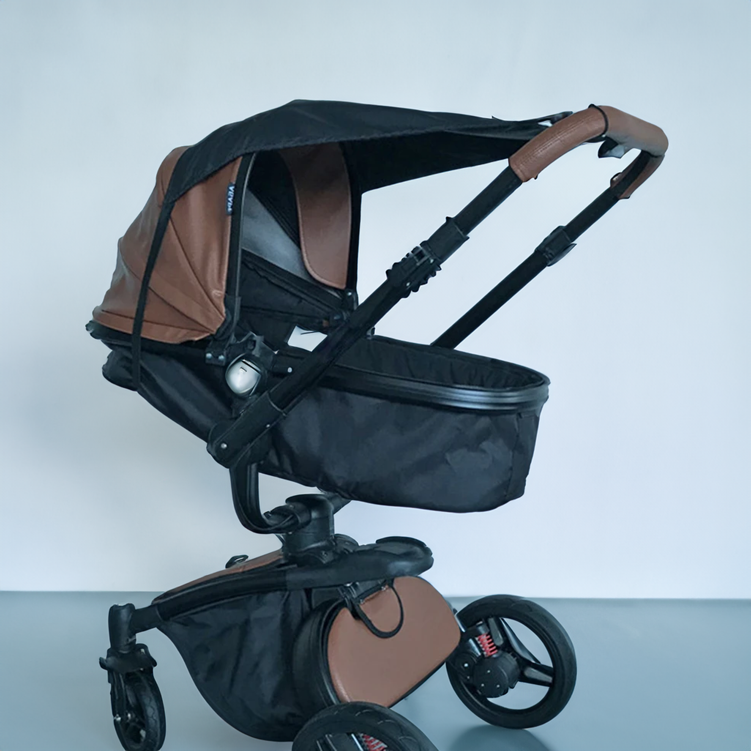 Ein brauner und schwarzer Kinderwagen mit Verdeck und einer schwarzen Babywanne.