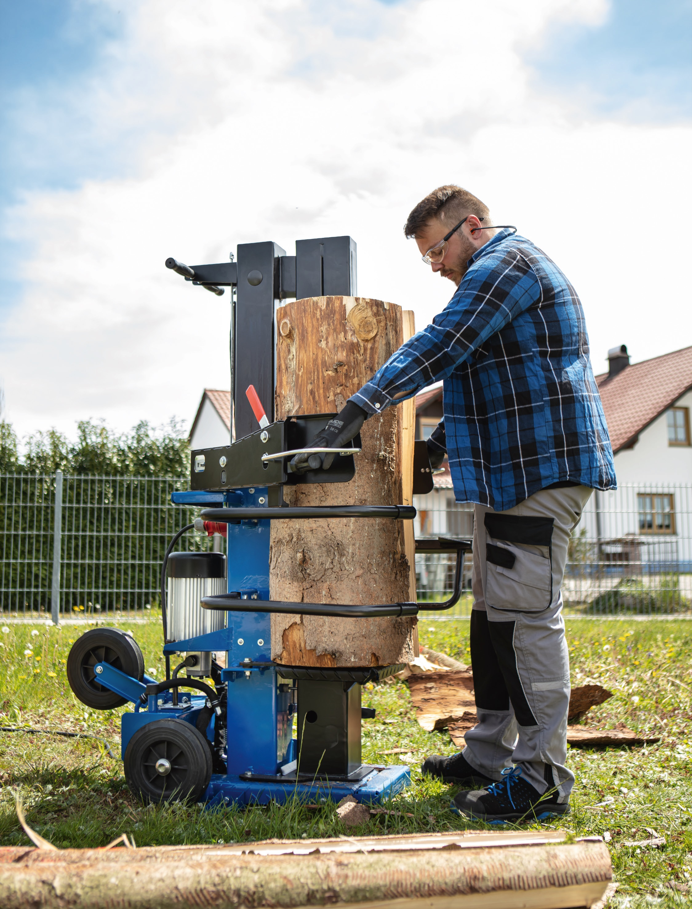 Man gebruikt een houtklover in een tuin op een zonnige dag.