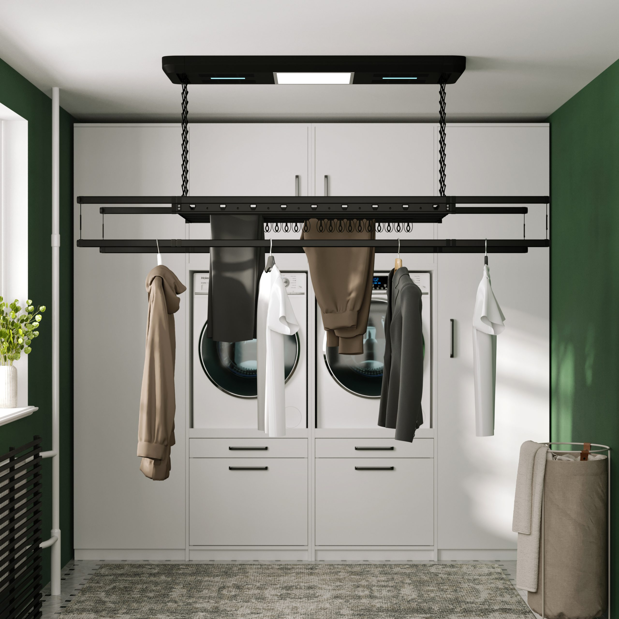 Wasruimte met hangende kleding, twee wasmachines en een droogrek. Groene muur.