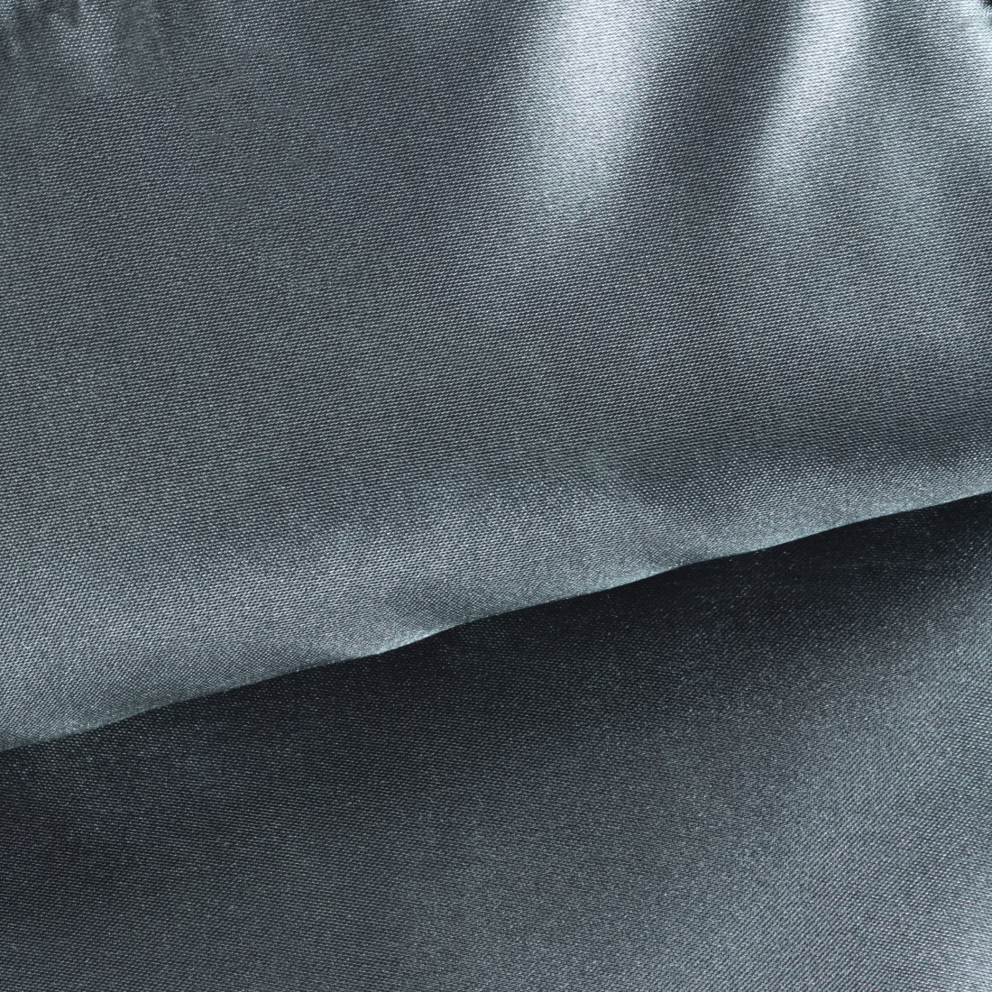 Zbliżenie szarej tkaniny z widoczną fakturą i fałdami. Tkanina jest warstwowa.