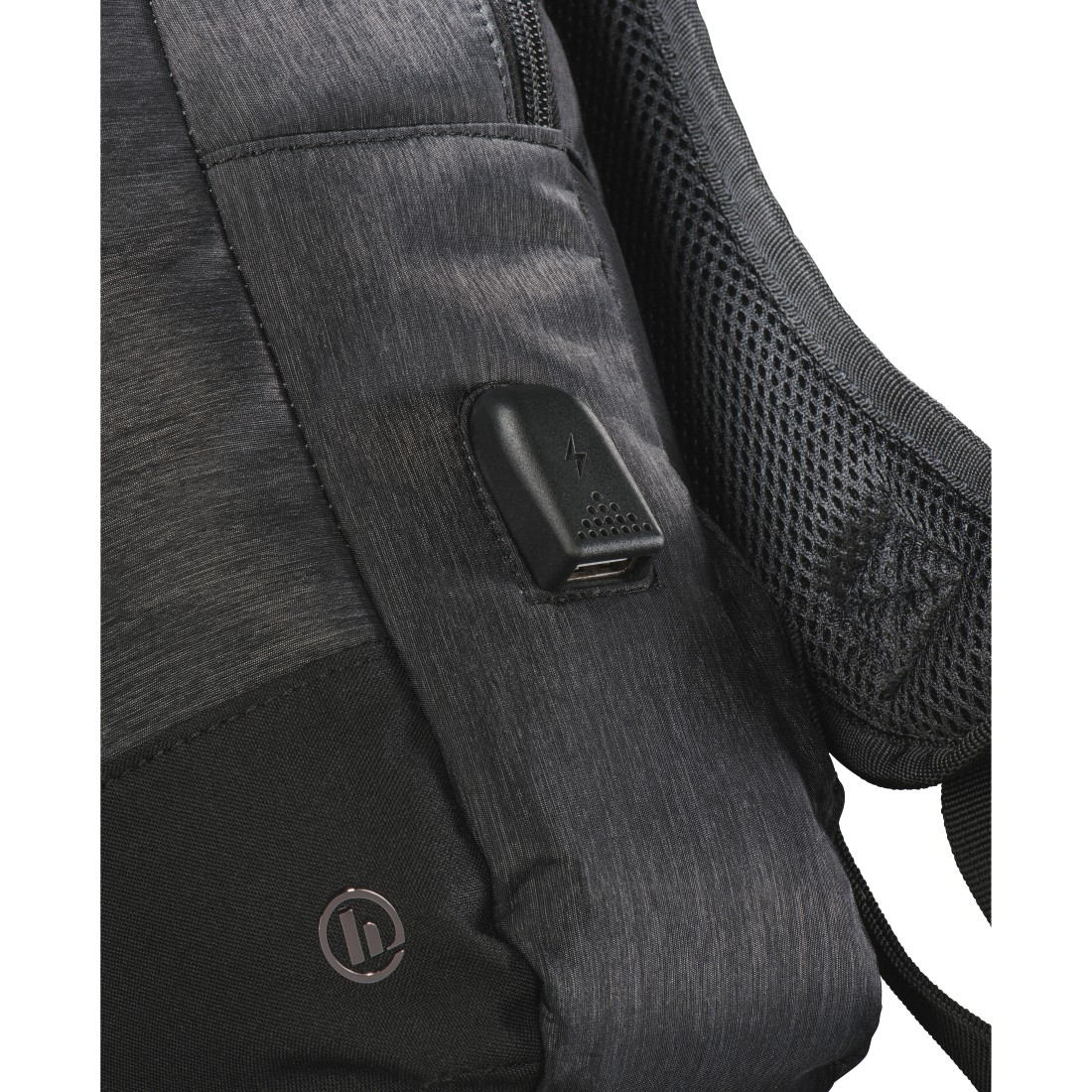 Primo piano di uno zaino nero con porta USB e logo su una superficie strutturata.
