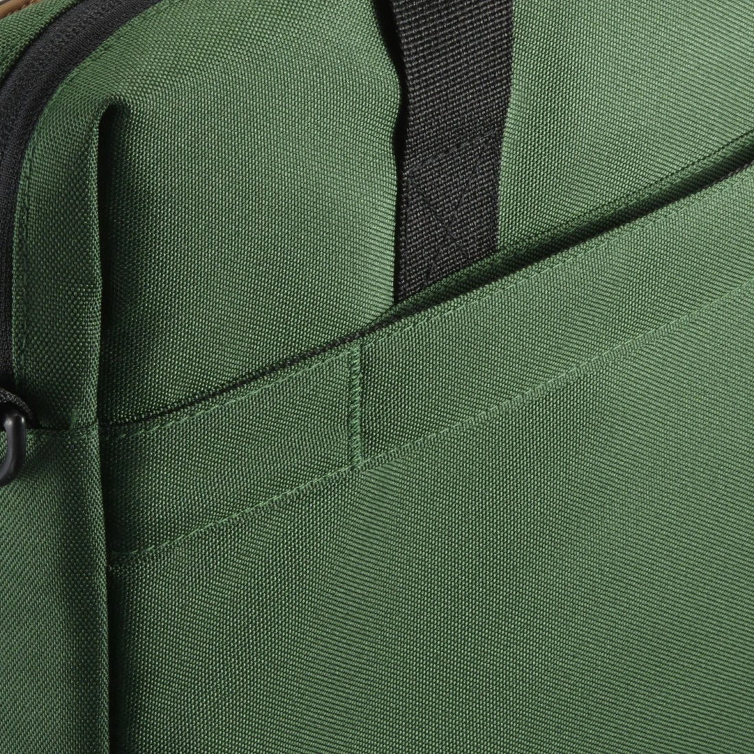 Primo piano di una borsa in tessuto verde con cerniera e cinturino neri.