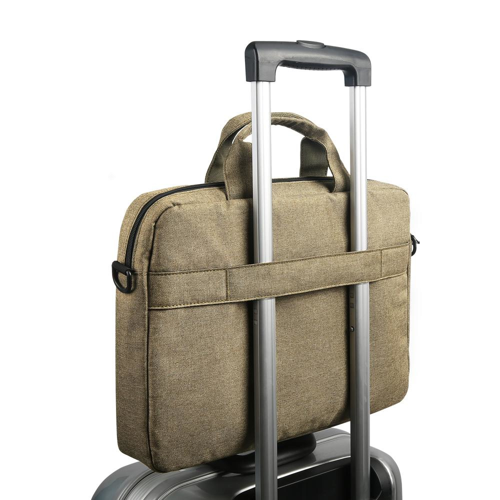 Una borsa marrone per laptop sopra una valigia. Ha un manico e una tracolla.