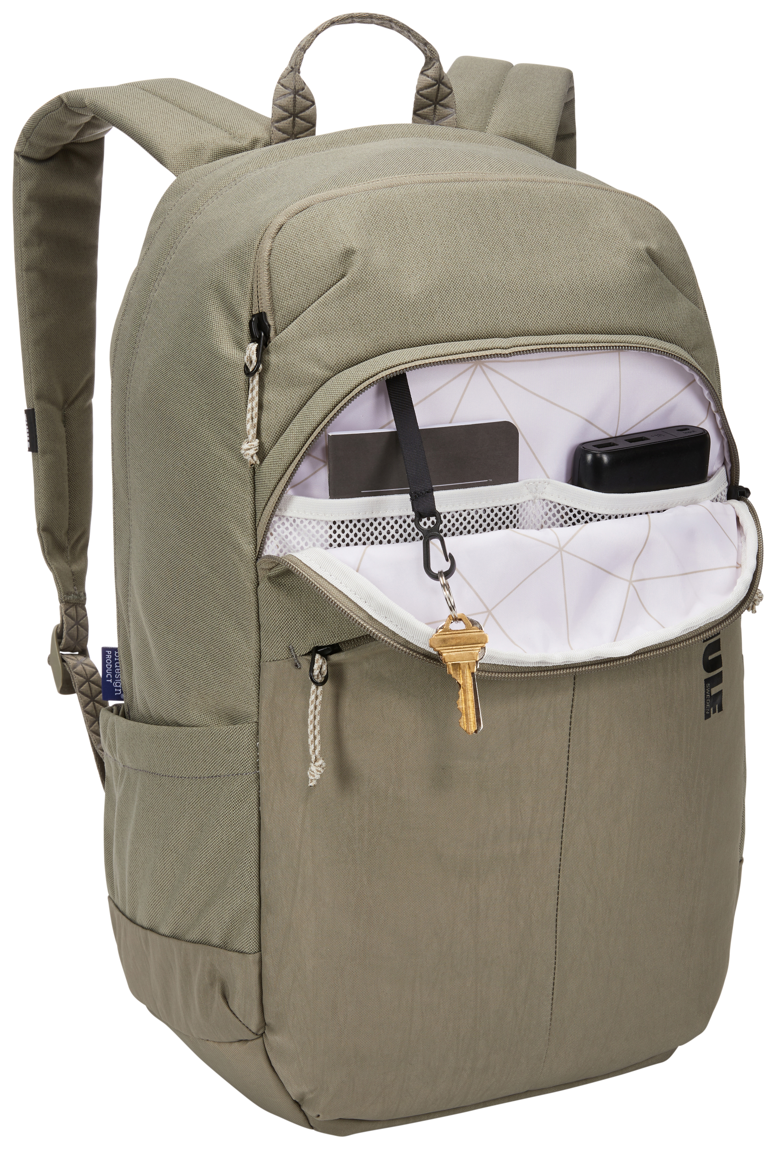 Ein beigefarbener Rucksack mit offenen Taschen. Ein Schlüssel hängt an einer Tasche. Der Rucksack steht vor weißem Hintergrund.