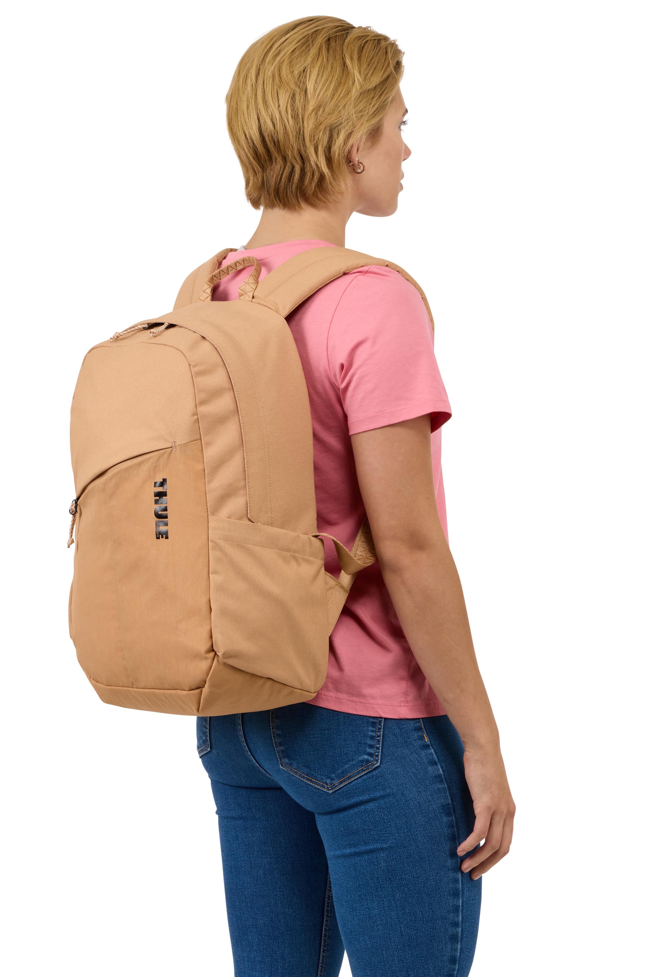 Frau mit beigem Rucksack und rosa Hemd, von hinten vor weißem Hintergrund gesehen.