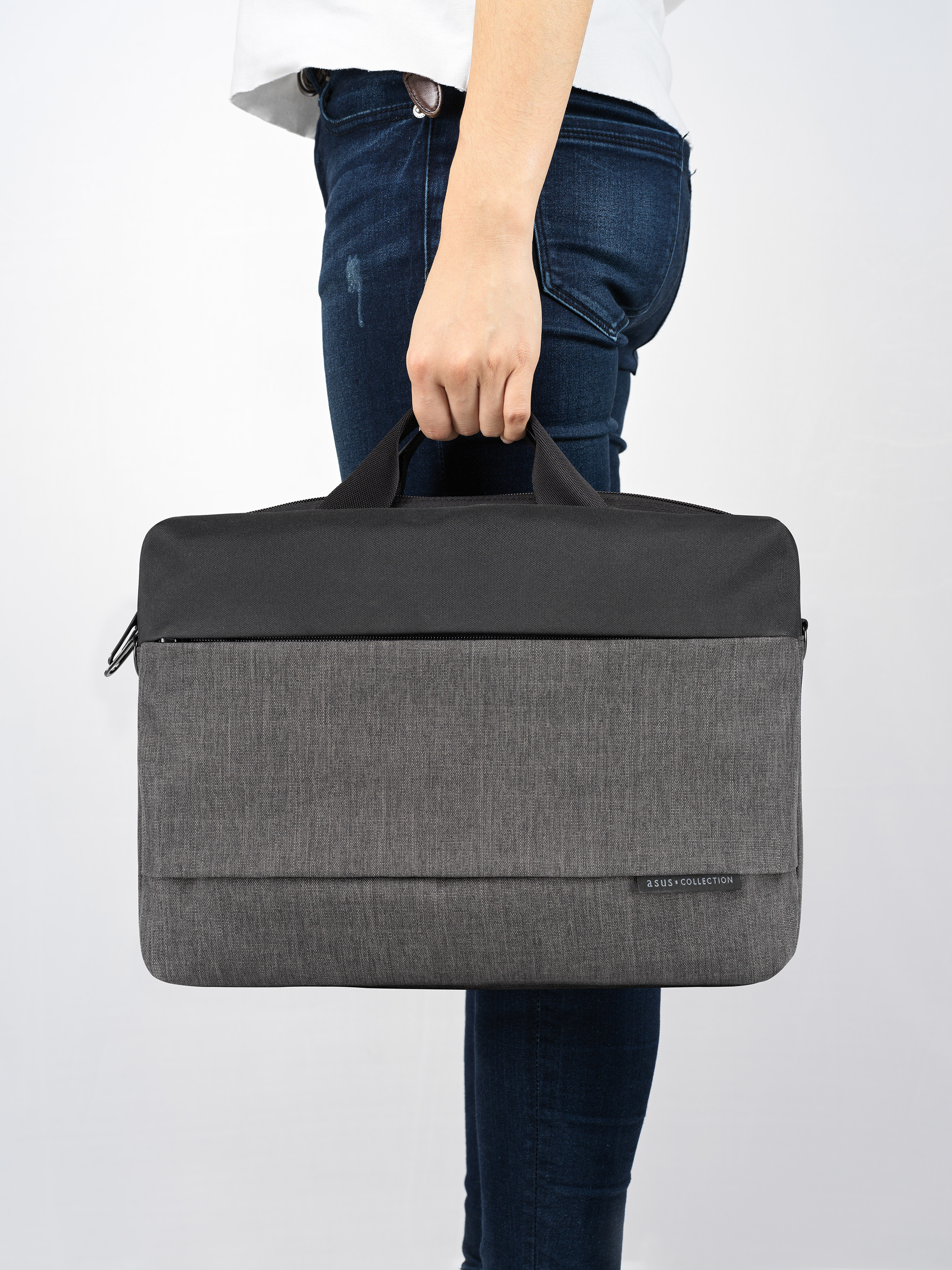 Una persona che tiene una borsa per laptop grigia e nera, su uno sfondo bianco.