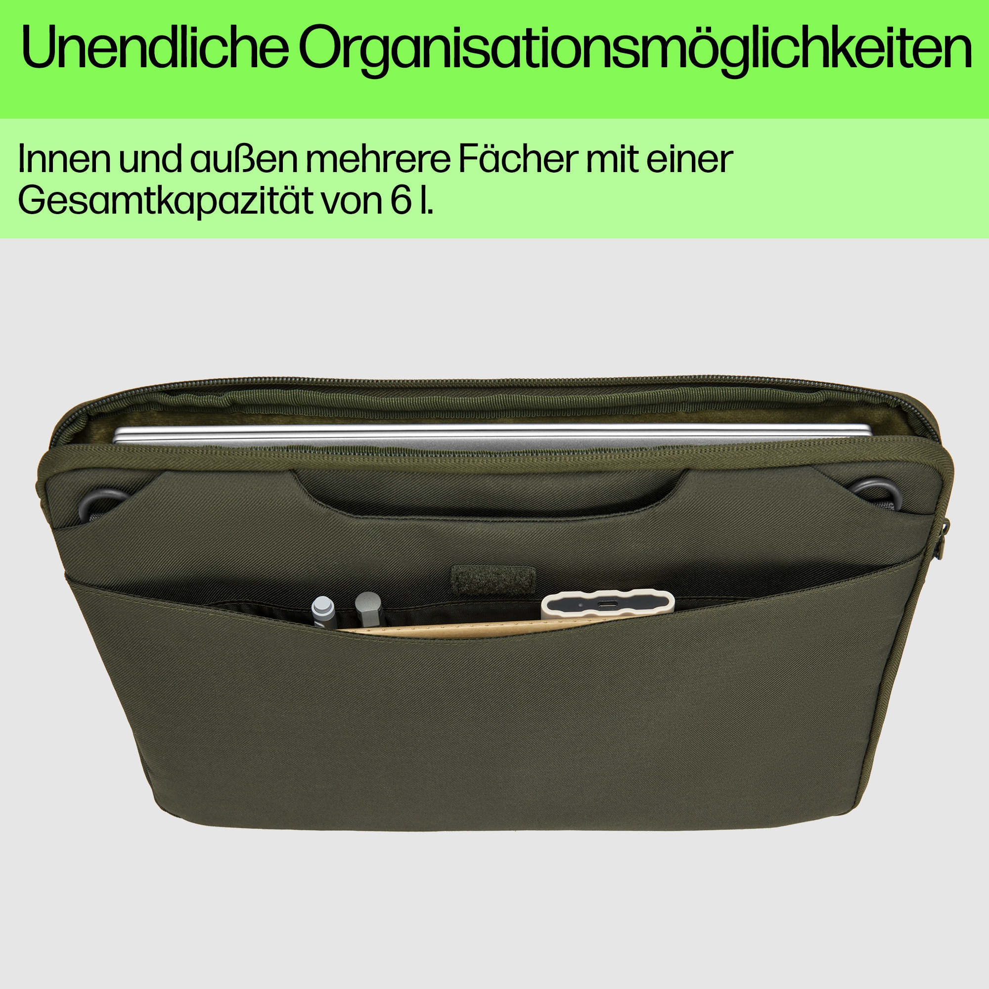 Interno borsa per laptop verde con laptop. Contiene penne, uno stilo e un piccolo accessorio.