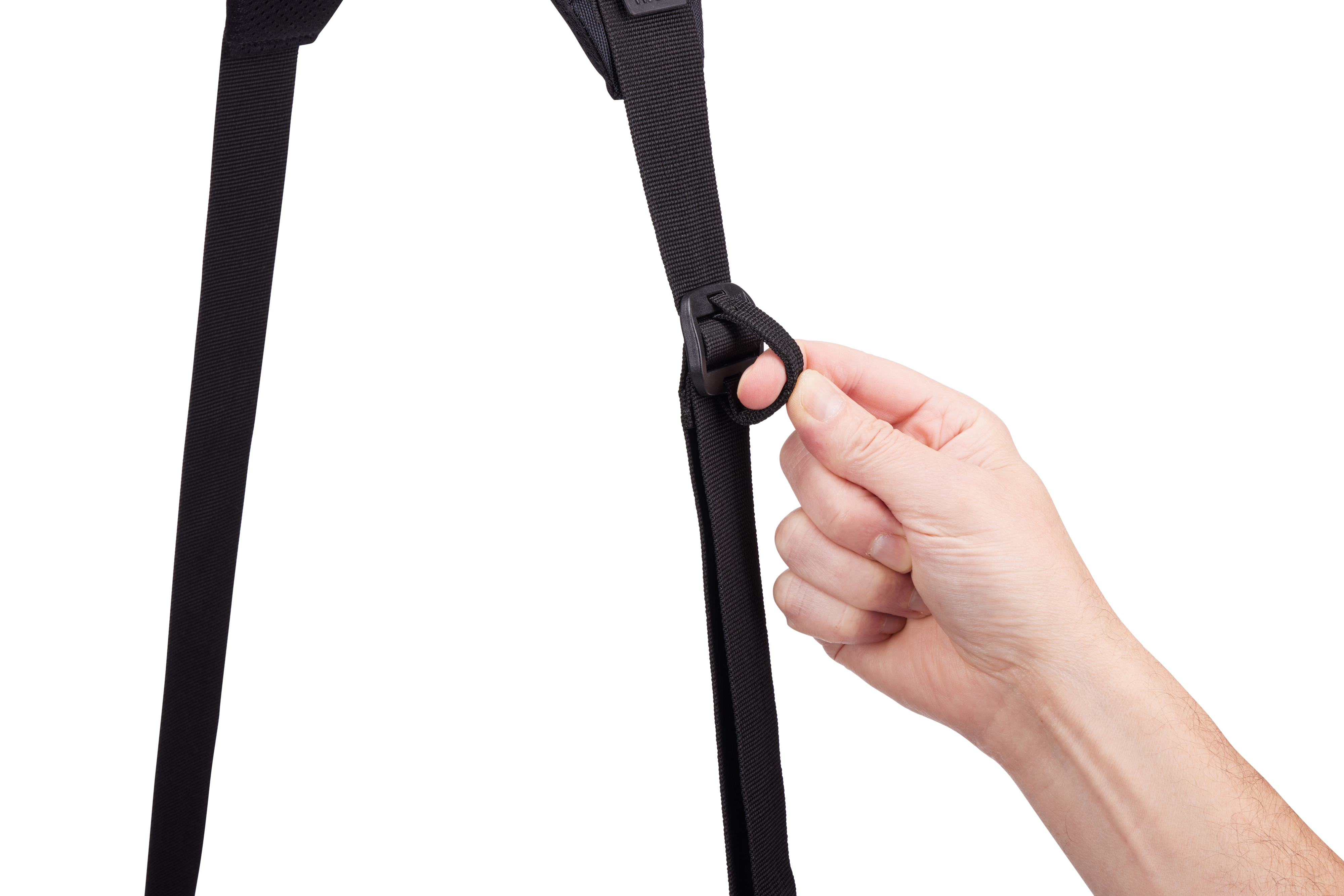 Una mano tiene una cinghia nera collegata a una borsa. La cinghia ha una fibbia di plastica.