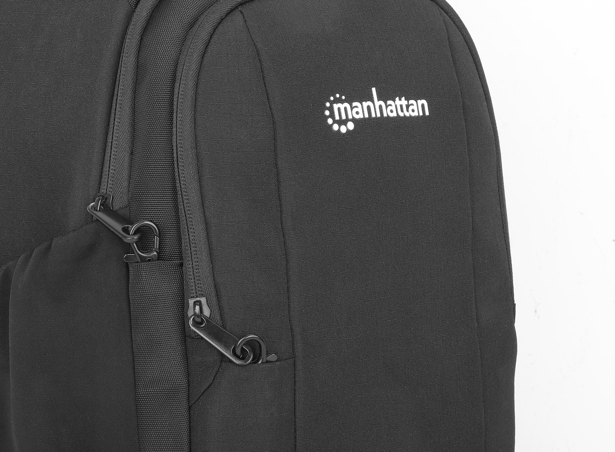 Zaino nero con cerniere e logo Manhattan. Sfondo chiaro.