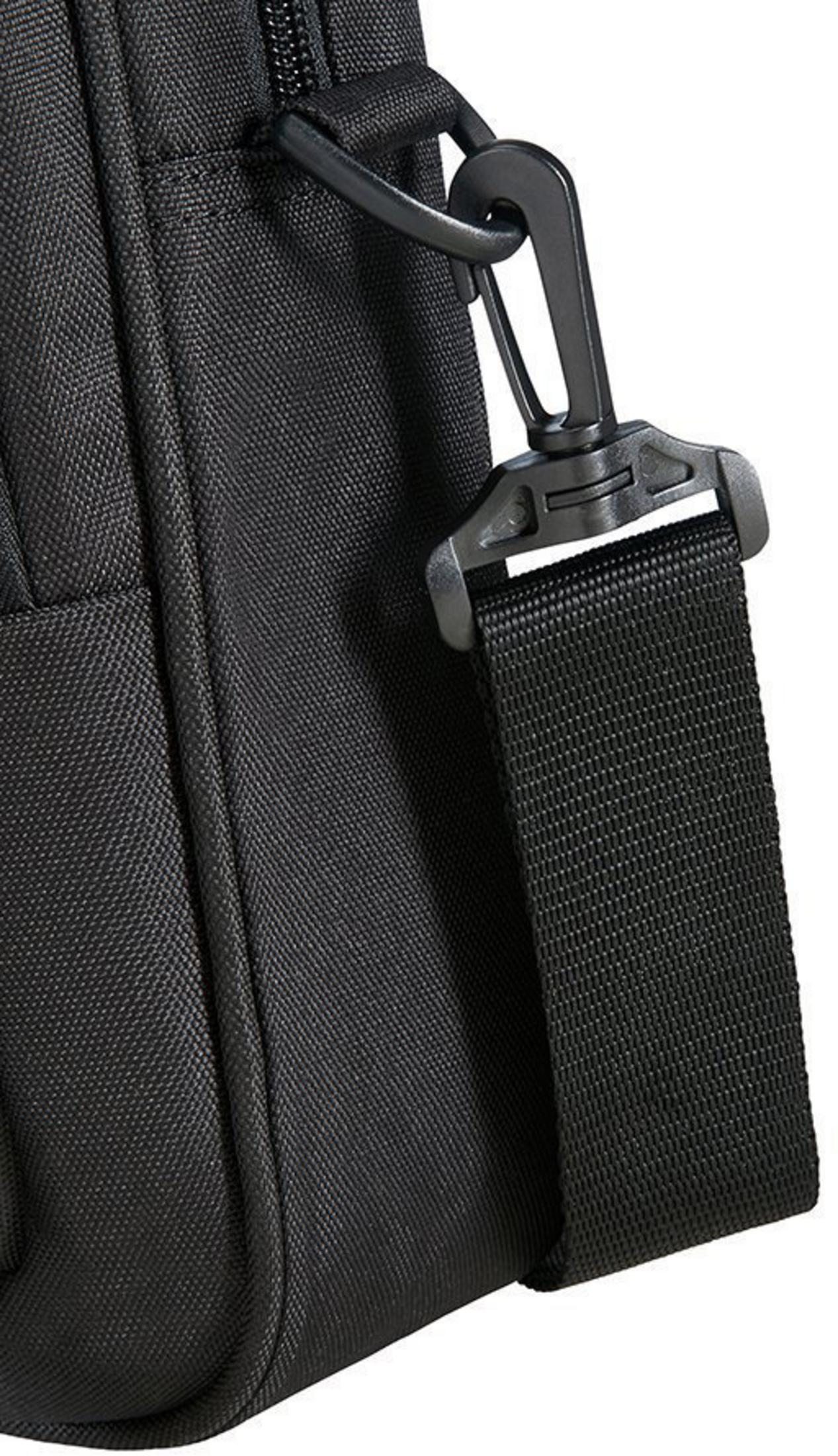 Primo piano di un cinturino per borsa per laptop nera con fibbia. Sfondo bianco.