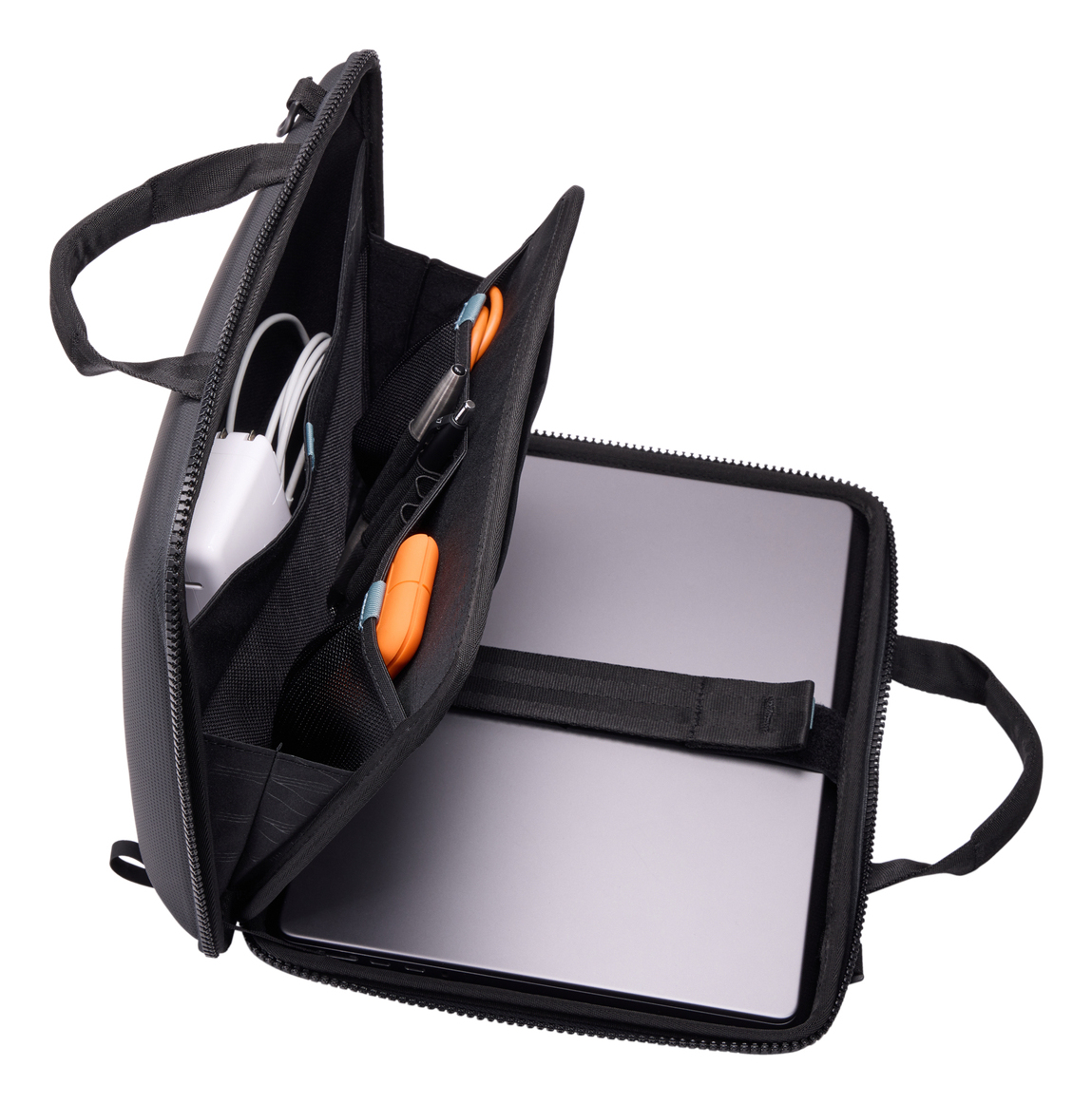 Borsa per laptop nera aperta che mostra l'interno. Diversi scomparti con oggetti all'interno. Isolato su bianco.