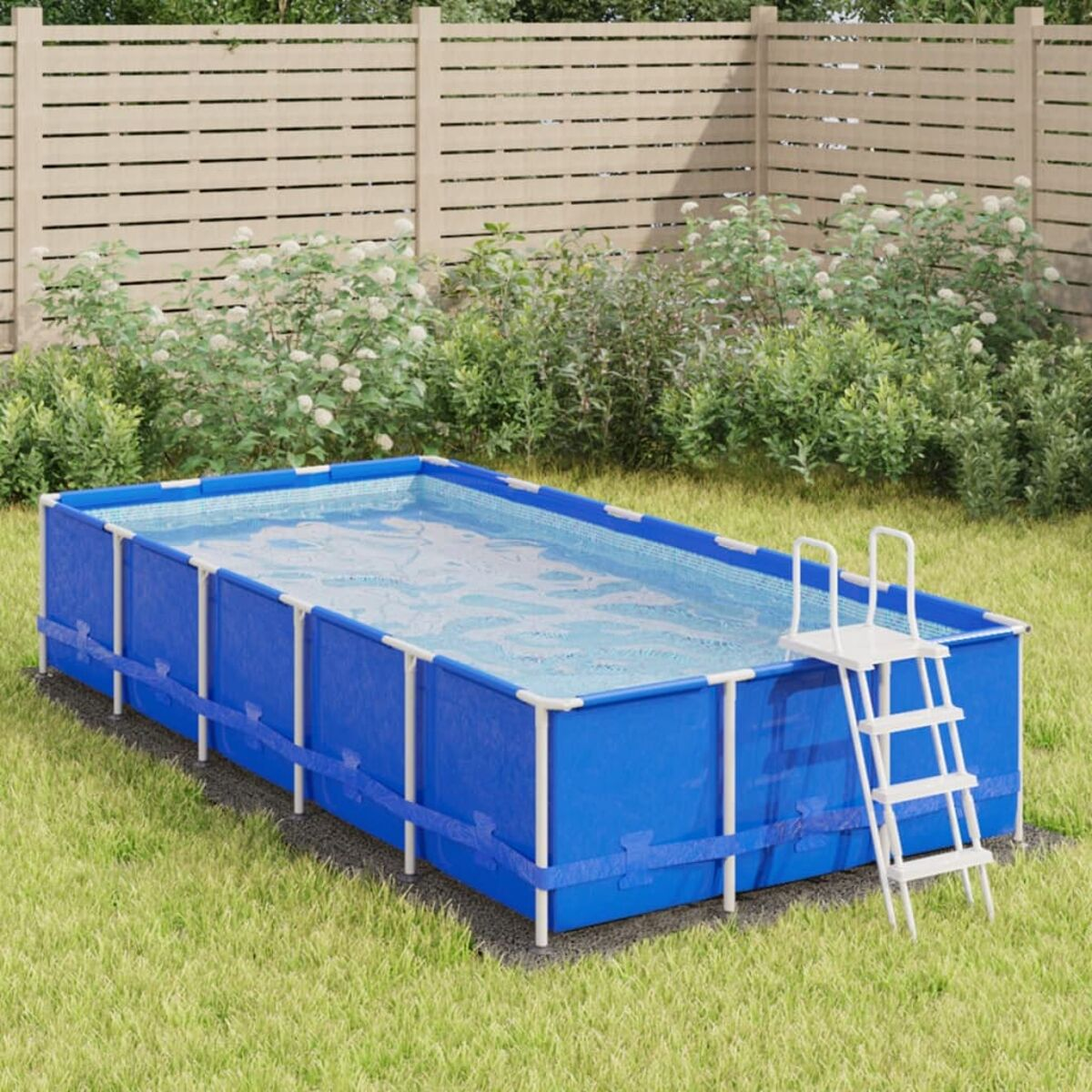 Rechteckiger blauer Pool im Hinterhof, mit weißer Leiter, umgeben von grünem Gras und einem Zaun.