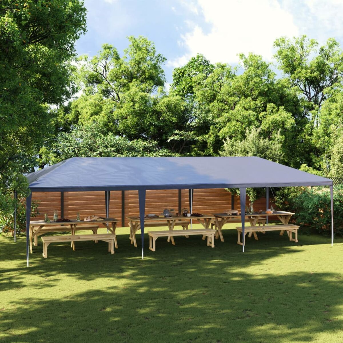 Graues Zelt mit Picknicktischen und Bänken auf Gras, in einem Garten mit Bäumen.