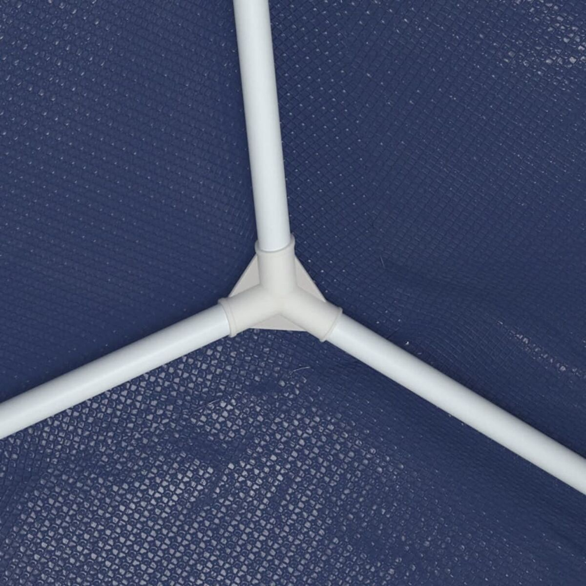 Nahaufnahme eines weißen Kunststoffgelenks, das drei weiße Rohre verbindet. Blauer Hintergrund.