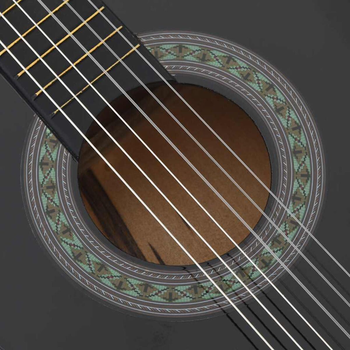 Nahaufnahme einer schwarzen Akustikgitarre. Schallloch und Saiten sind sichtbar.