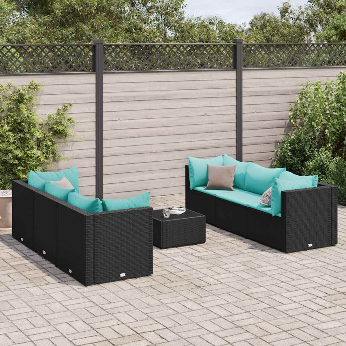 Mobiliario de patio exterior con marcos negros y cojines turquesa. El fondo tiene una valla.