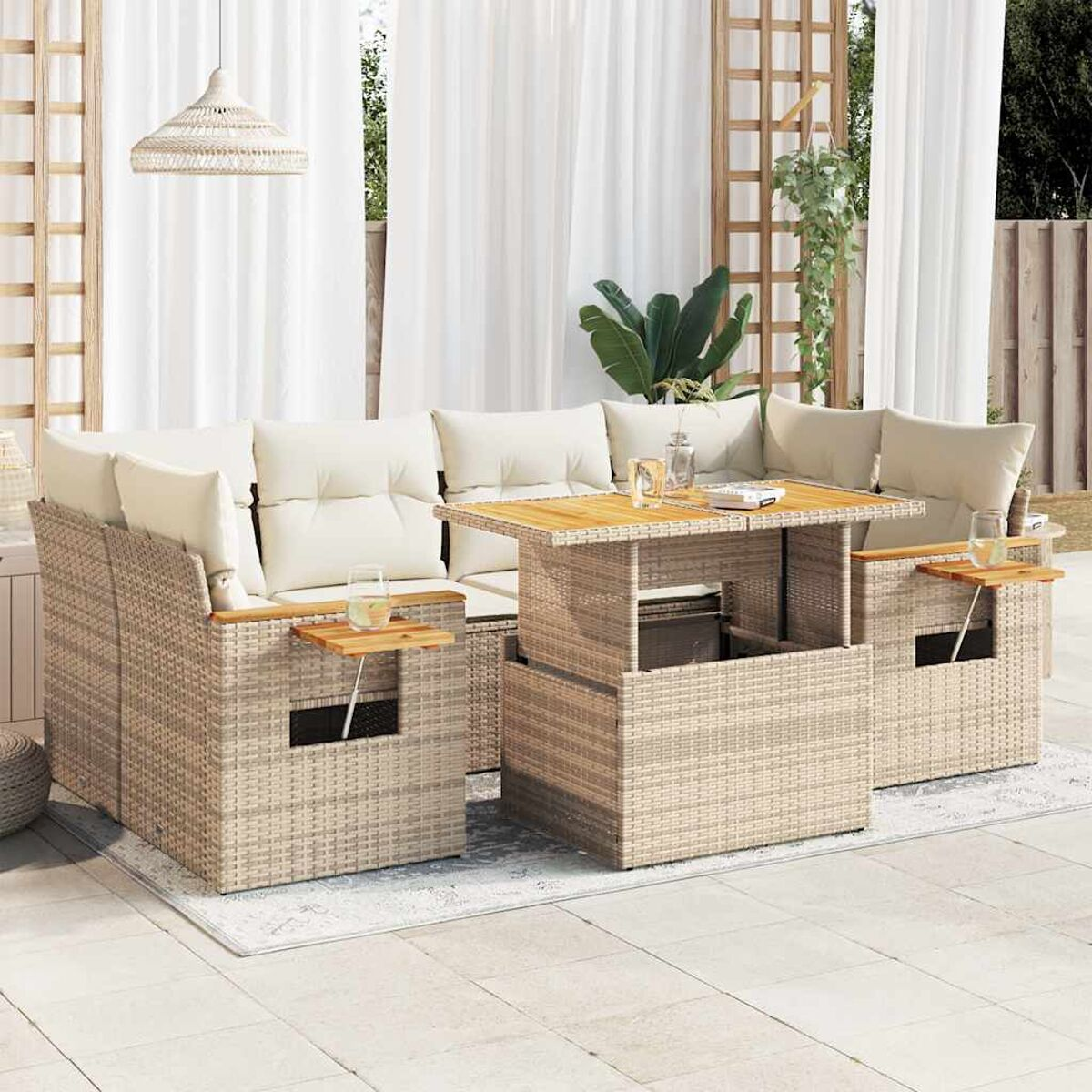Set di mobili da esterno in rattan con cuscini, tavolo e bevande. Sfondo bianco.