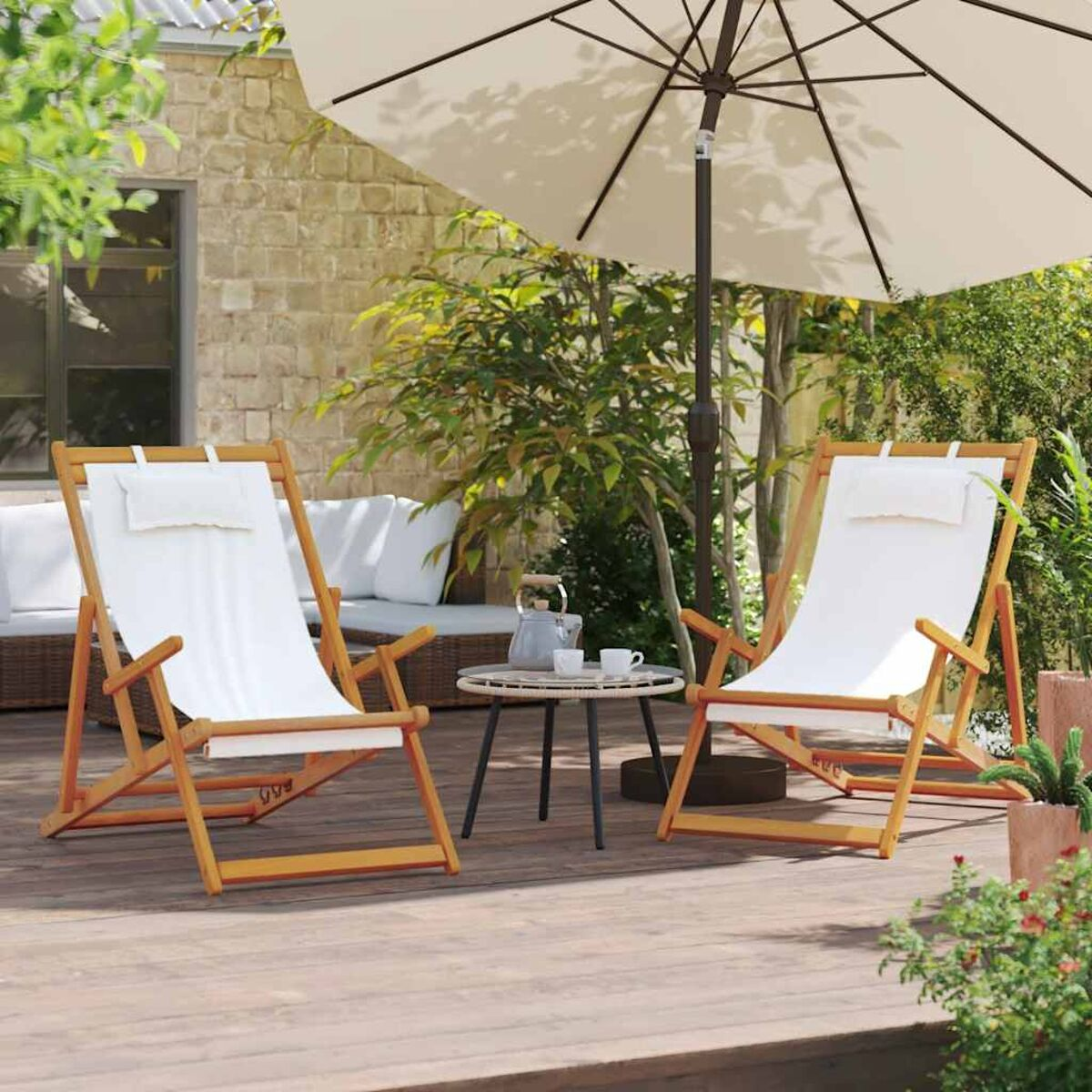 Zwei Holz-Deckstühle mit weißen Kissen unter einem großen Sonnenschirm, auf einem Holzdeck.