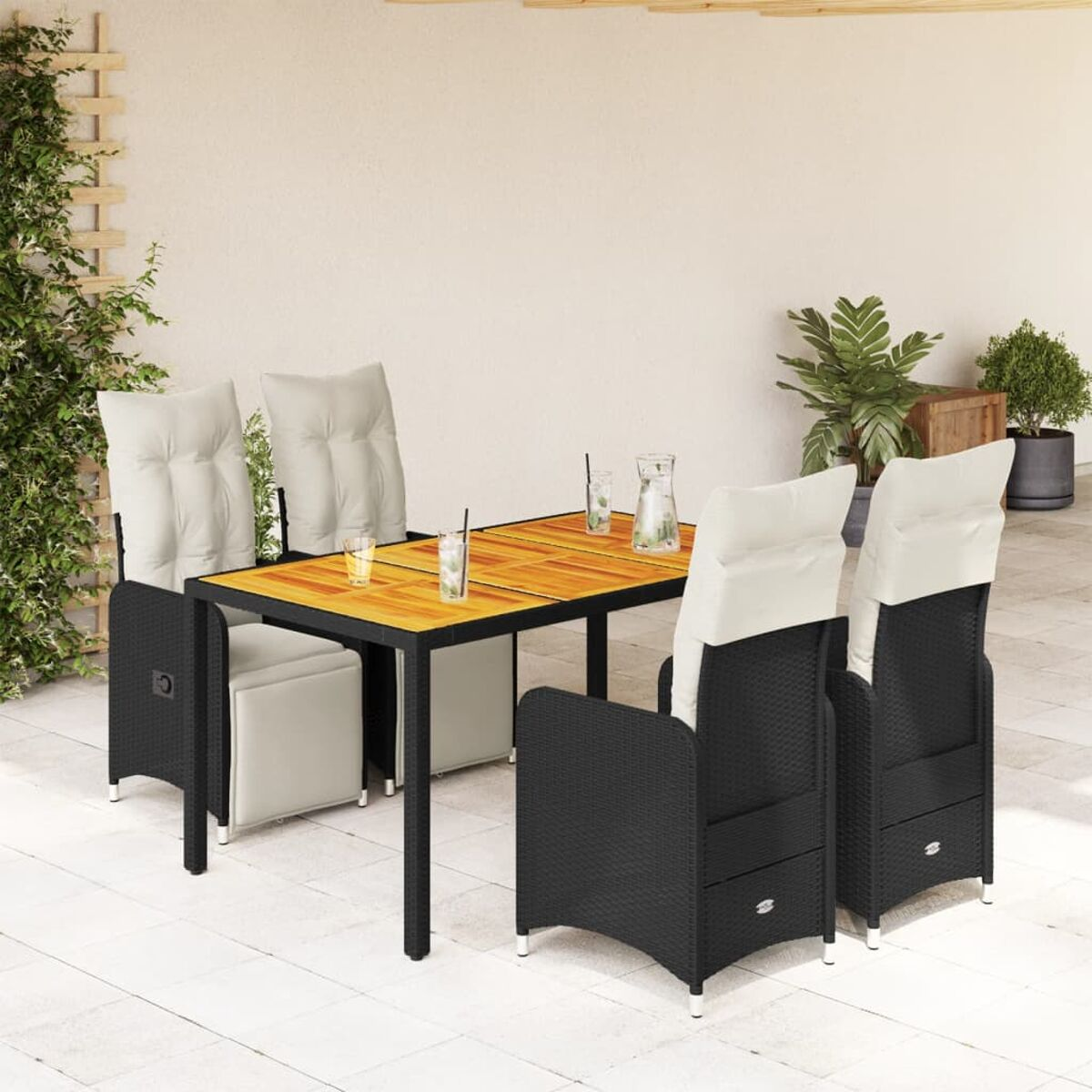 Set da pranzo all'aperto con sedie in vimini nere e tavolo in legno. Cuscini bianchi sulle sedie.