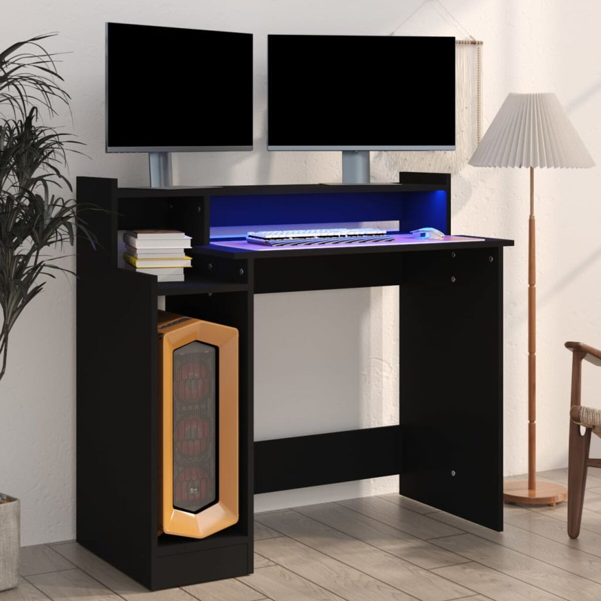 Schwarzer Computertisch mit zwei Monitoren, PC und Lampe. Weißer Wandhintergrund.