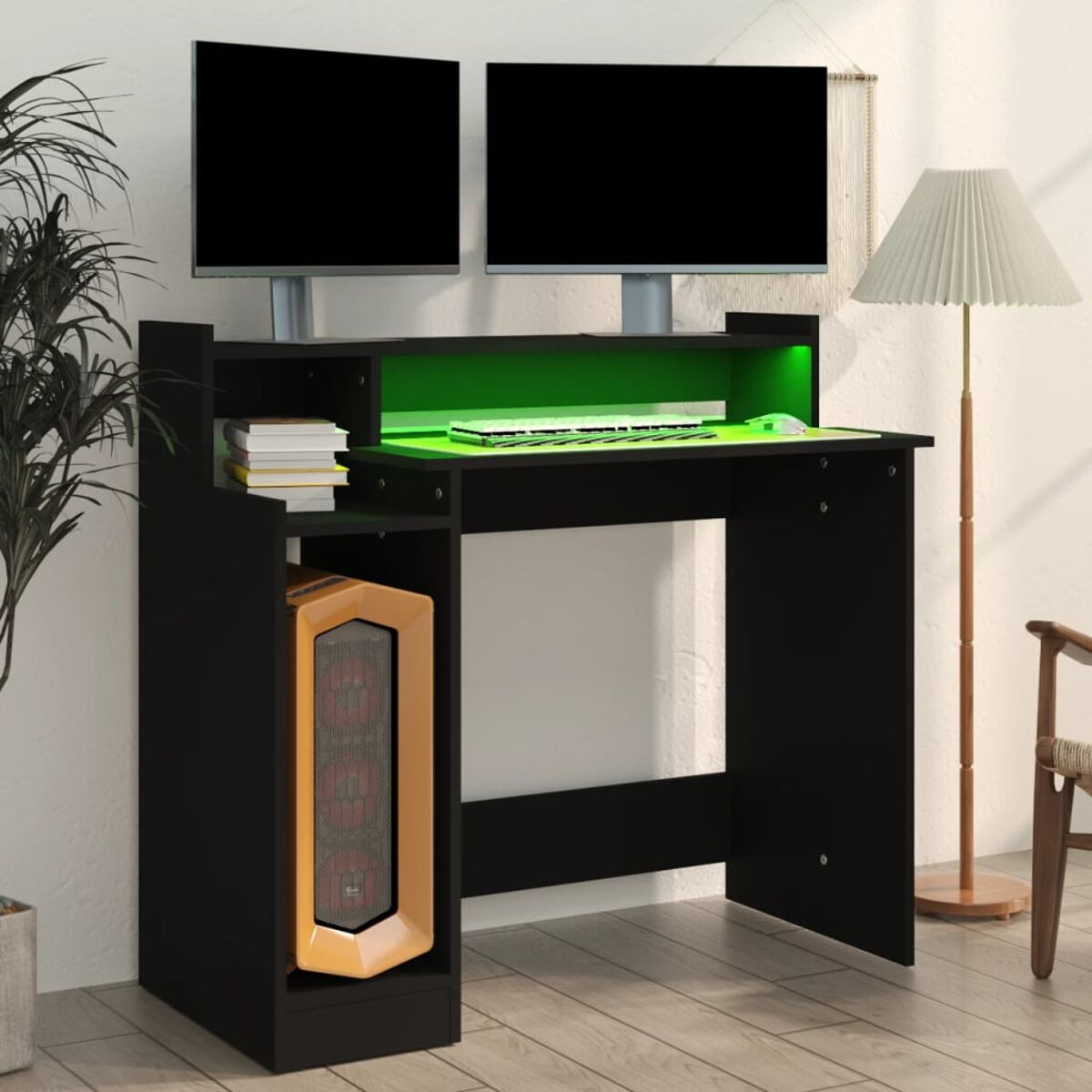 Schwarzer Gaming-Schreibtisch mit zwei Monitoren, einem PC-Tower und grüner LED-Beleuchtung. Der Hintergrund ist weiß.
