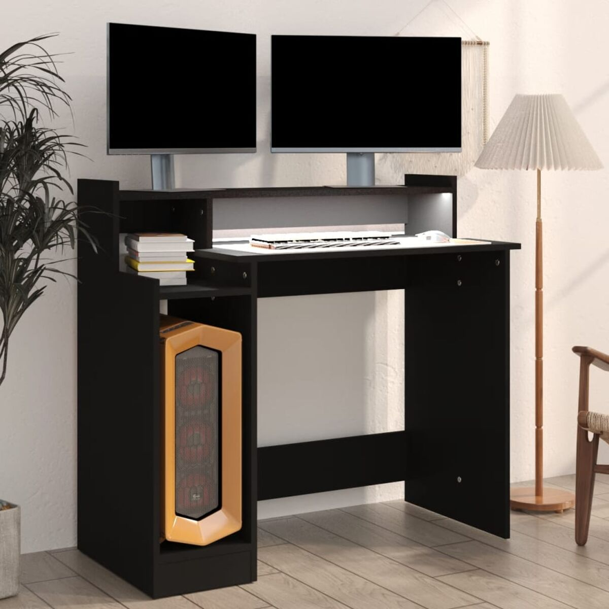Ein schwarzer Schreibtisch mit zwei Monitoren, einem Computer und einer Pflanze.