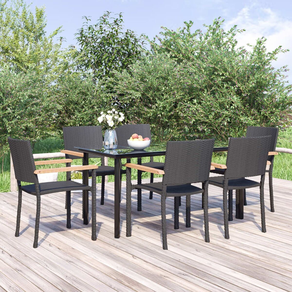 Essgruppe im Freien mit schwarzem Tisch, sechs Stühlen und Blumen. Grünes Laub im Hintergrund.