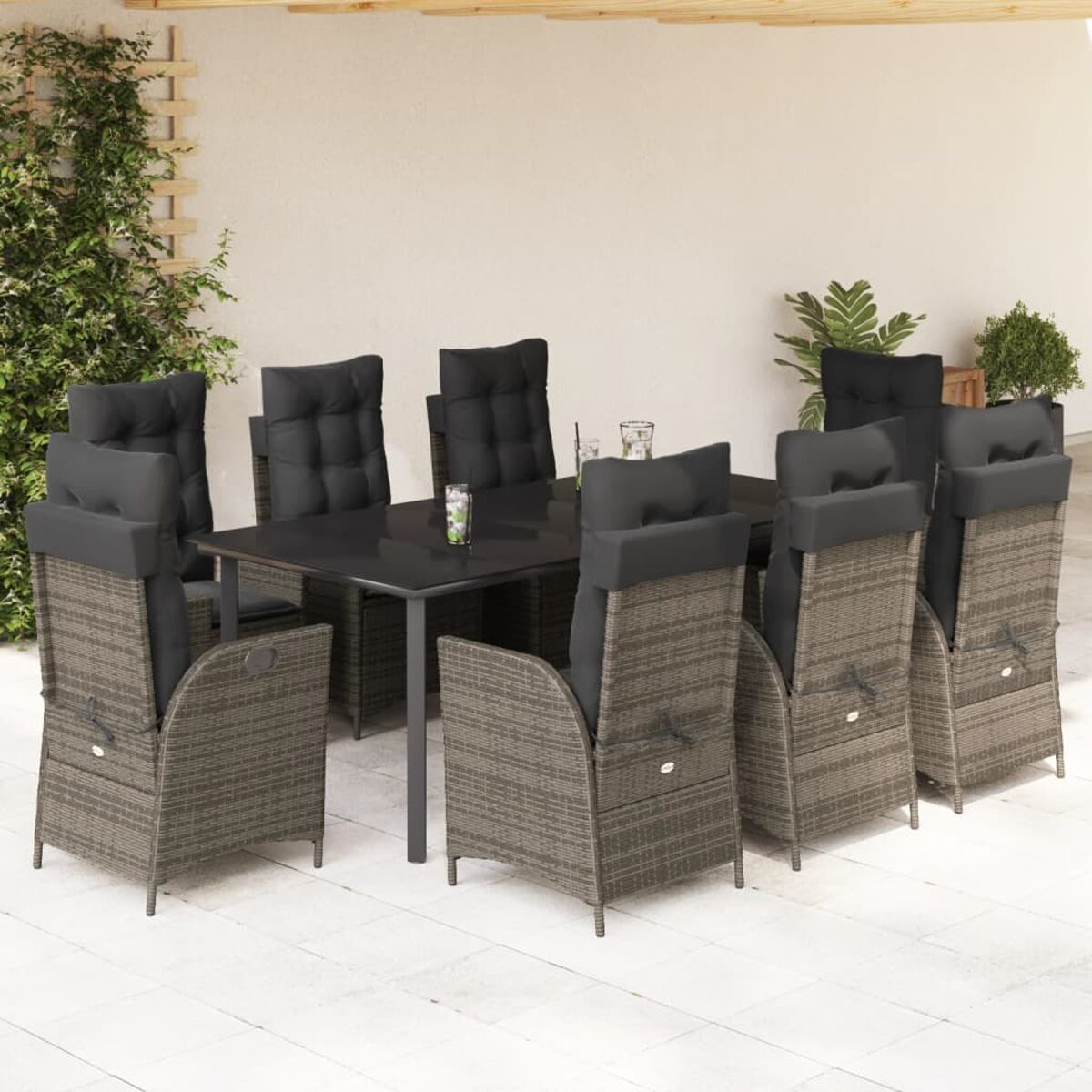 Essgruppe im Freien: Korbstühle mit schwarzen Kissen um einen schwarzen Tisch.