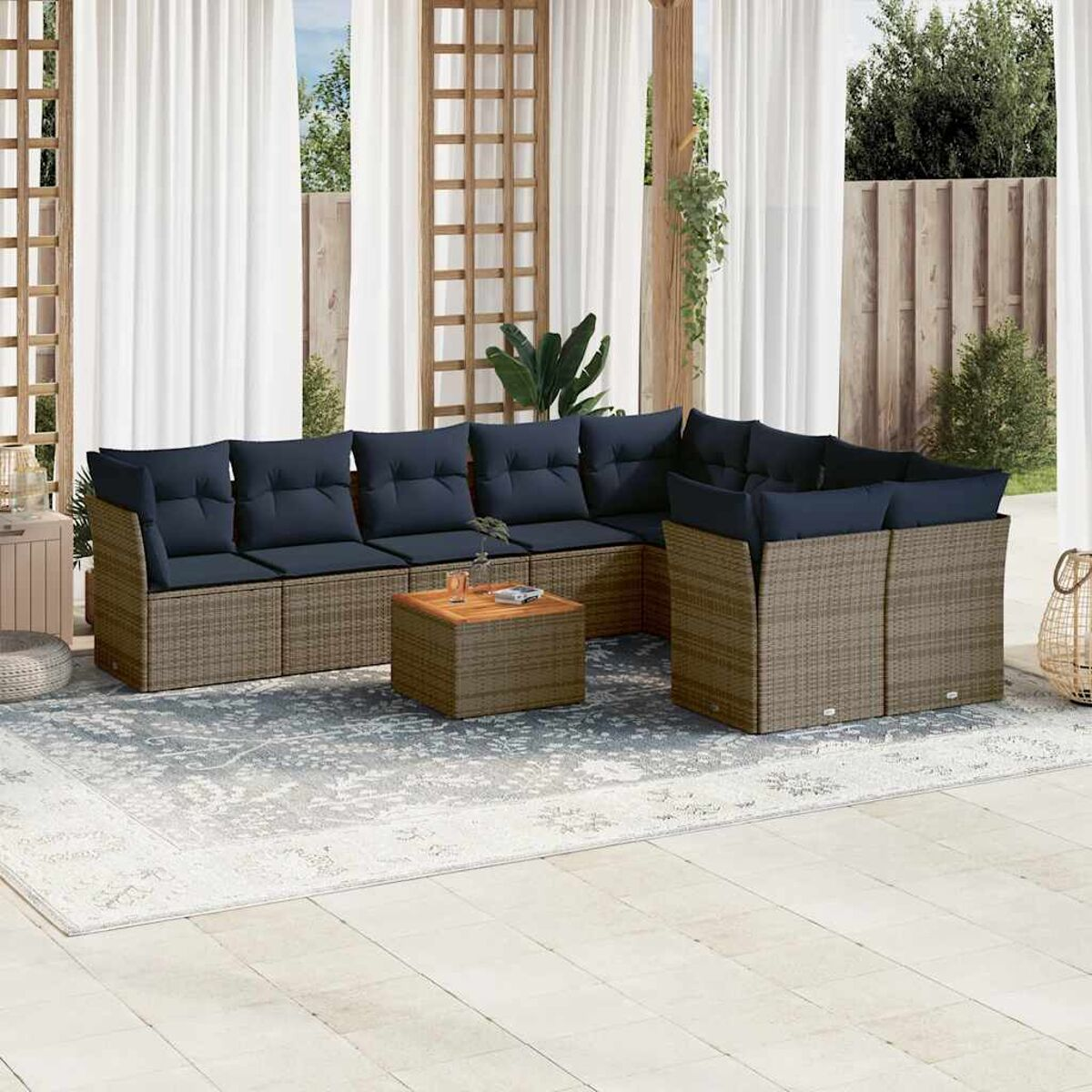 Divano componibile da esterno con cuscini blu, tavolino e tappeto su un patio.