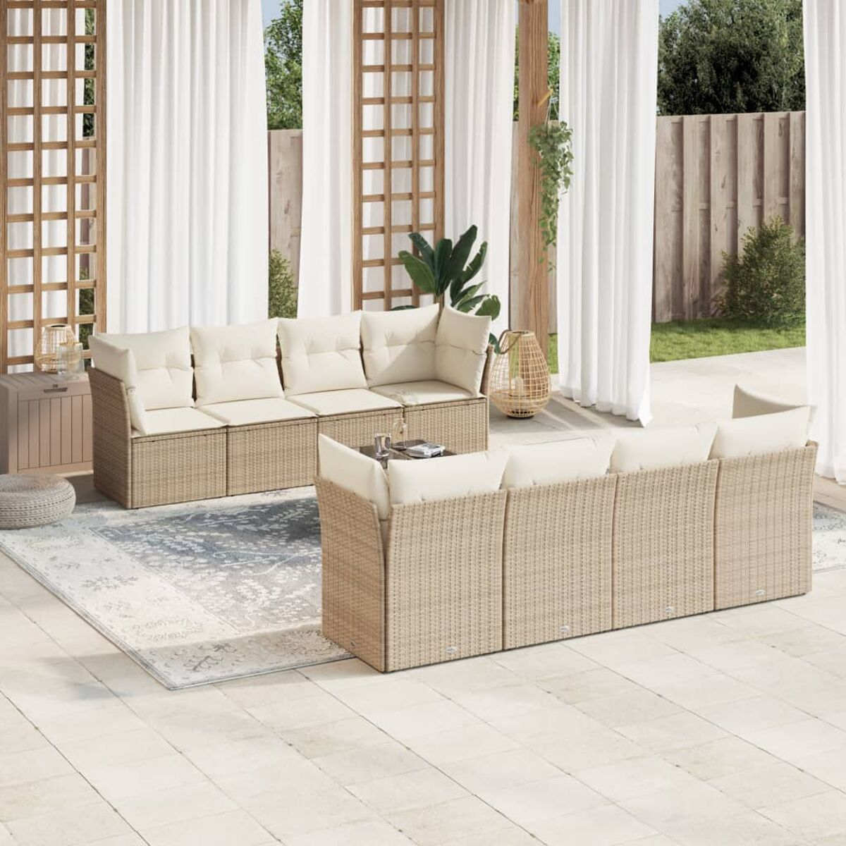 Terrassenmöbel-Set mit hellen Kissen und einem Teppich auf einer Terrasse mit Vorhängen.