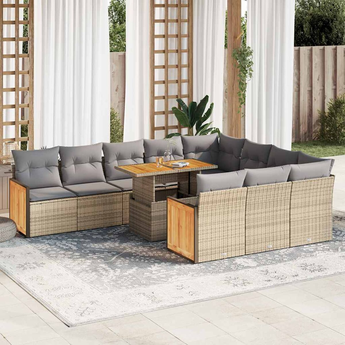 Set da patio esterno con cuscini grigi. Divano, tavolo e tappeto. Tende bianche sullo sfondo.