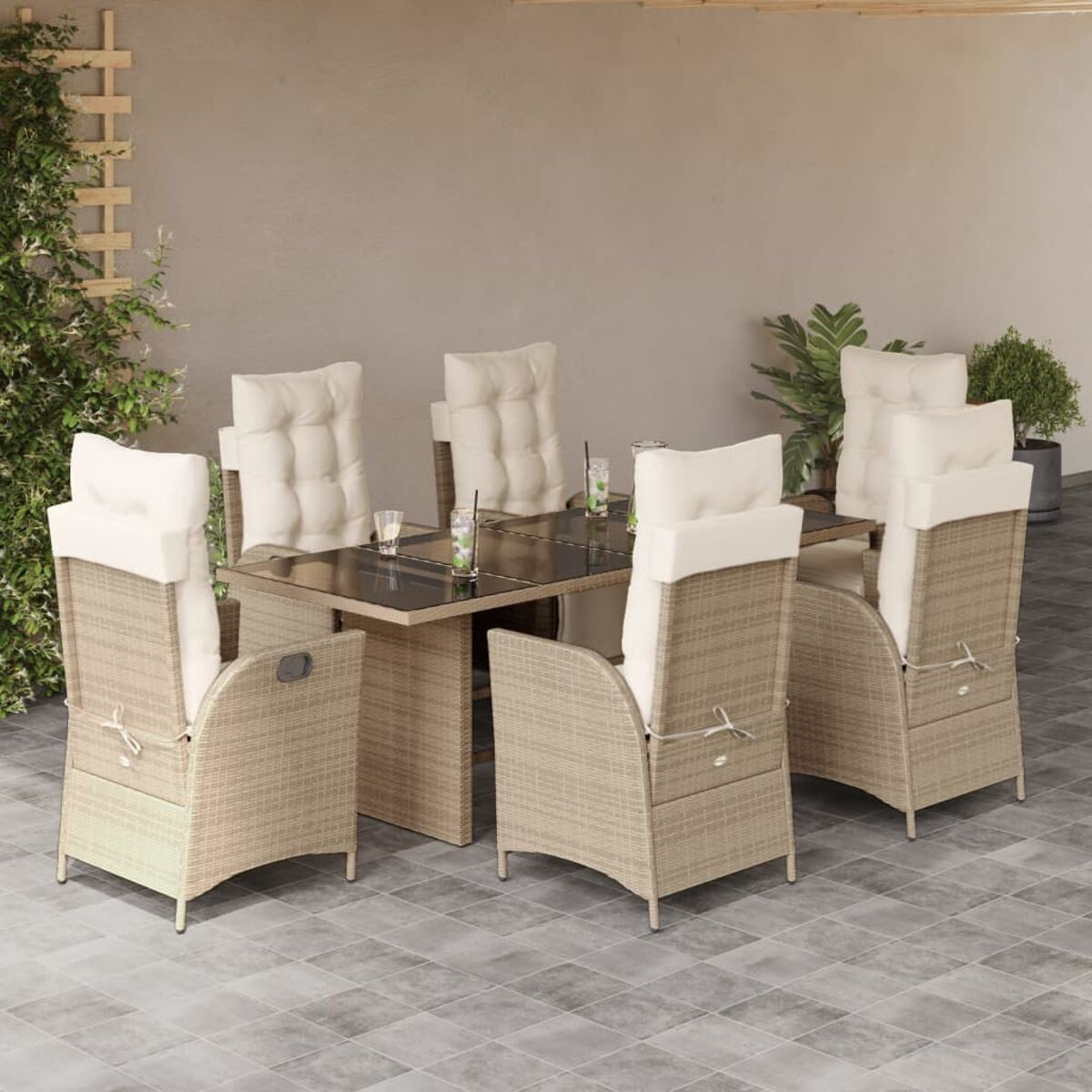 Outdoor-Essgruppe mit beigefarbenen Korbstühlen und einem Tisch mit Glasplatte. Kissen und Getränke sind sichtbar.