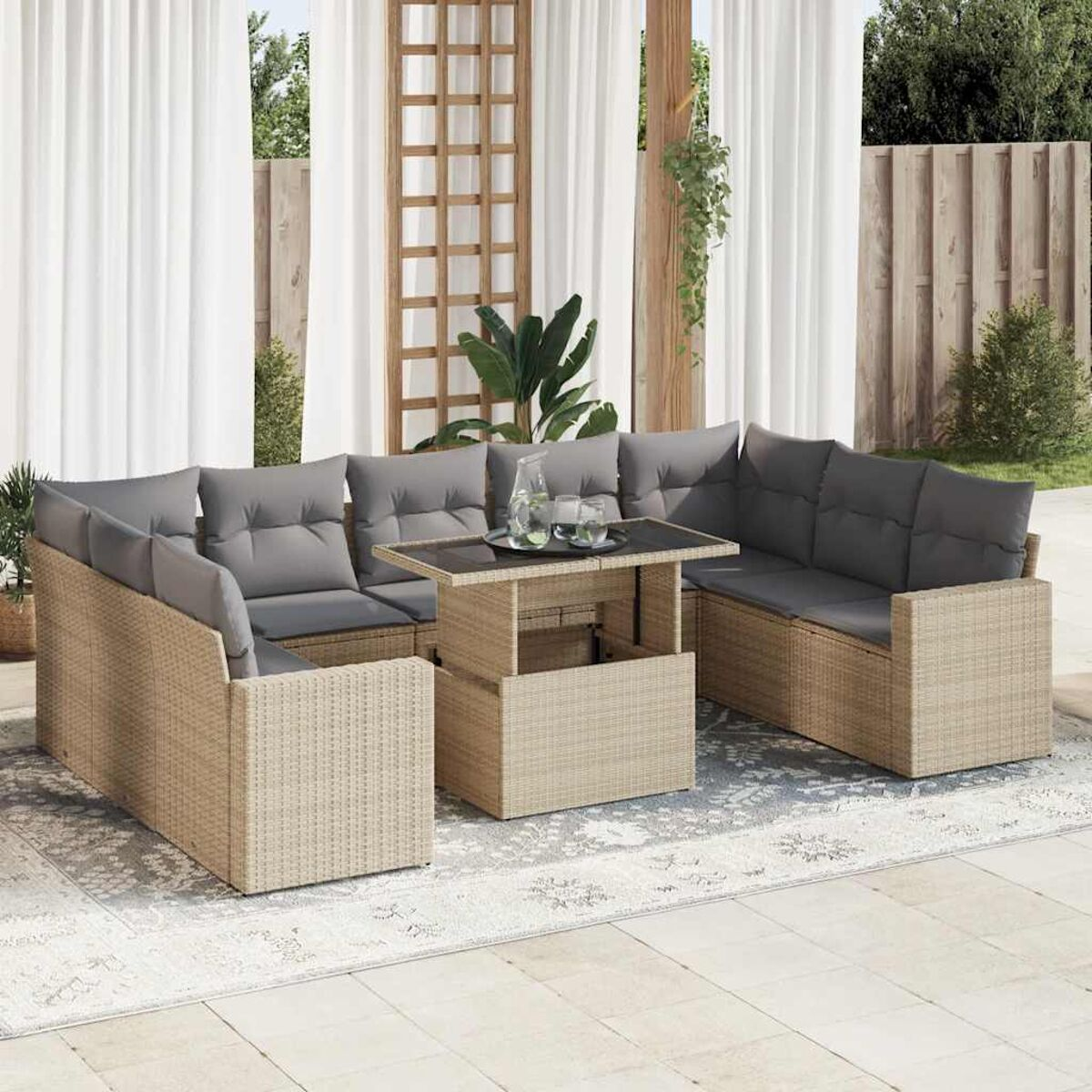 Ein beiges Outdoor-Sofa aus Rattan mit Kissen und Tisch.
