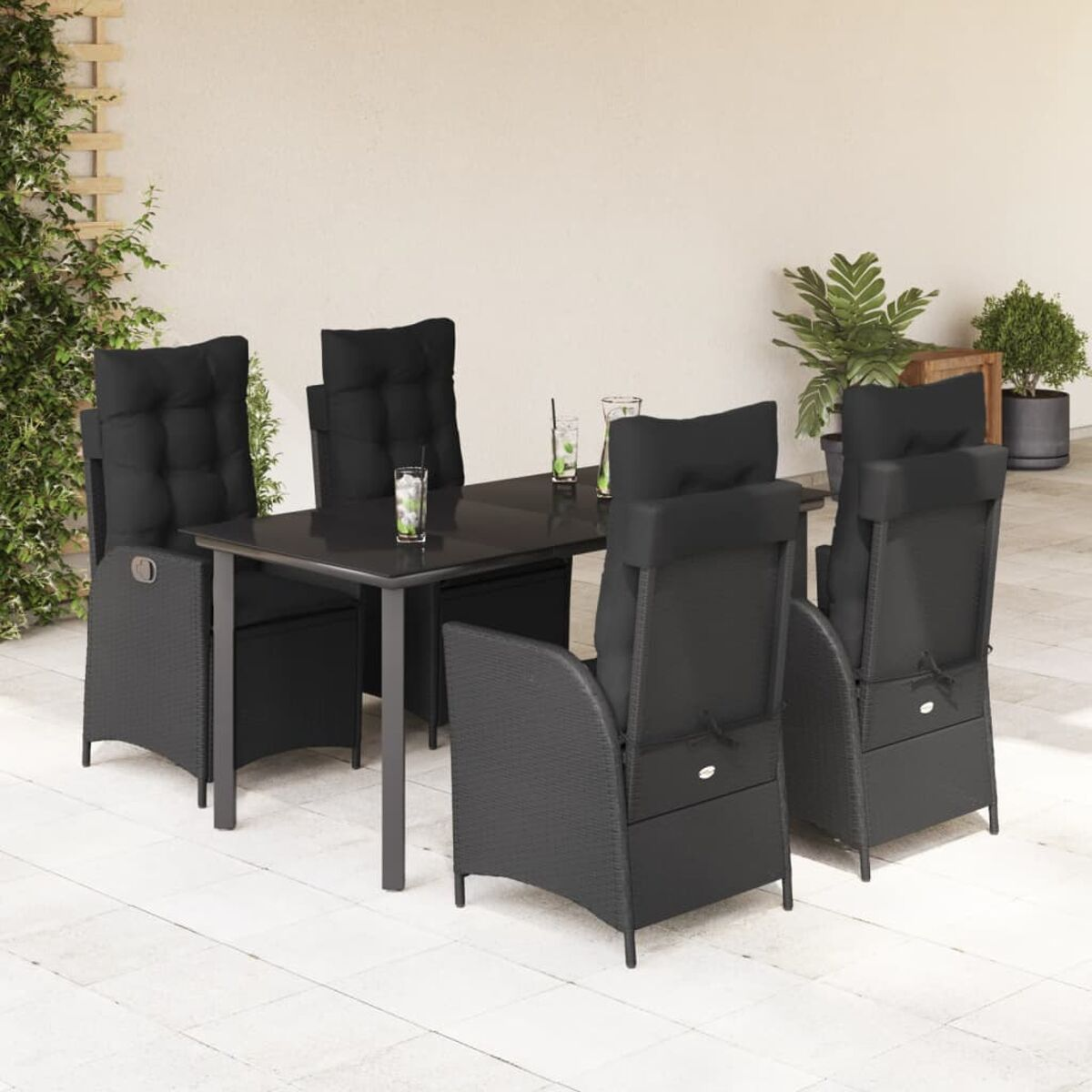 Schwarzer Tisch und Stühle. Tisch in der Mitte, mit Gläsern. Stühle haben schwarze Kissen.