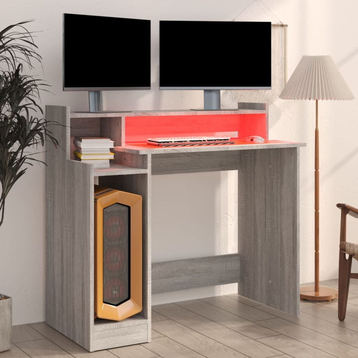 Ein grauer Computertisch mit Tower, Monitoren und Tastatur. In einem Raum.