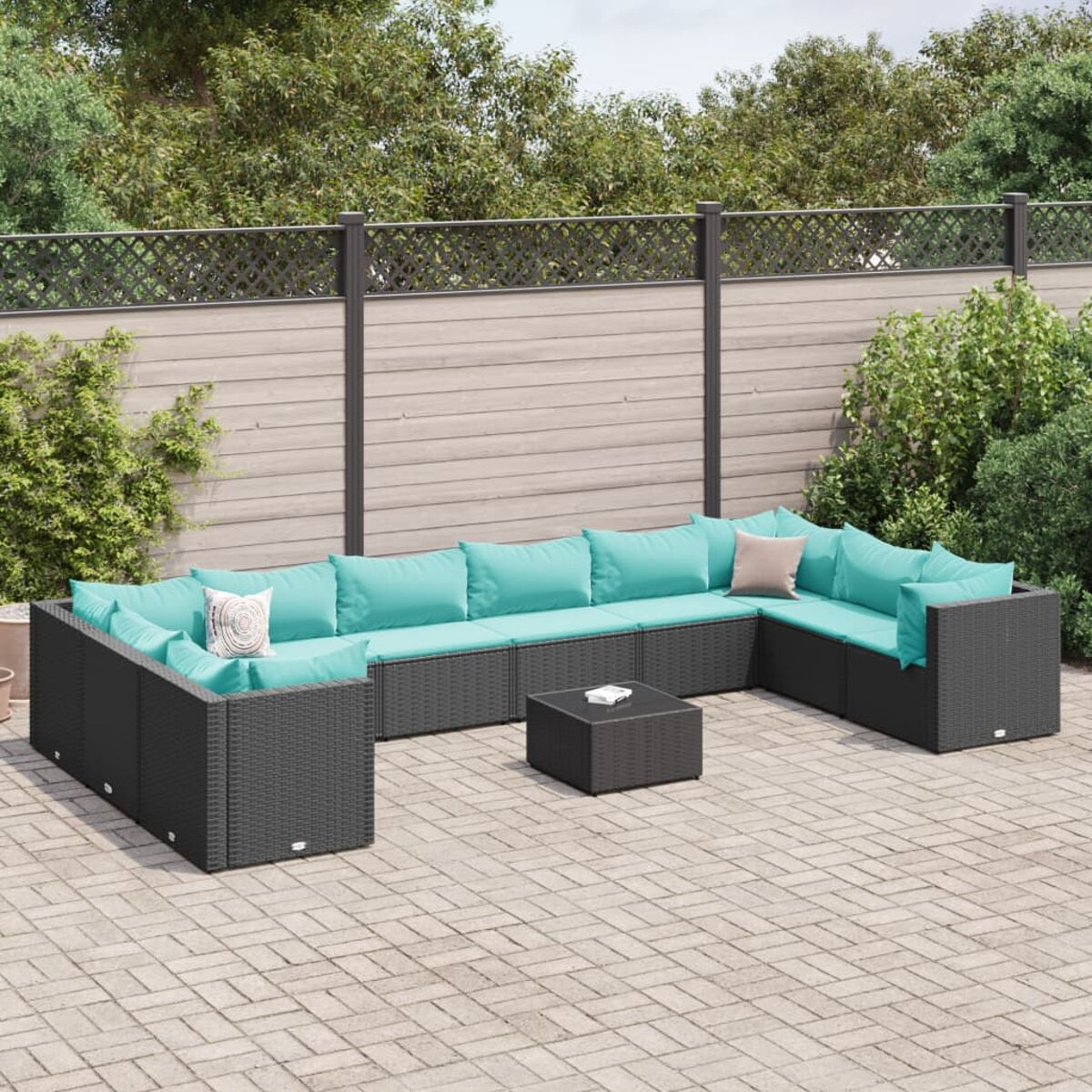 Divano componibile per esterni a forma di U con cuscini verde acqua. Telaio nero, su un patio.