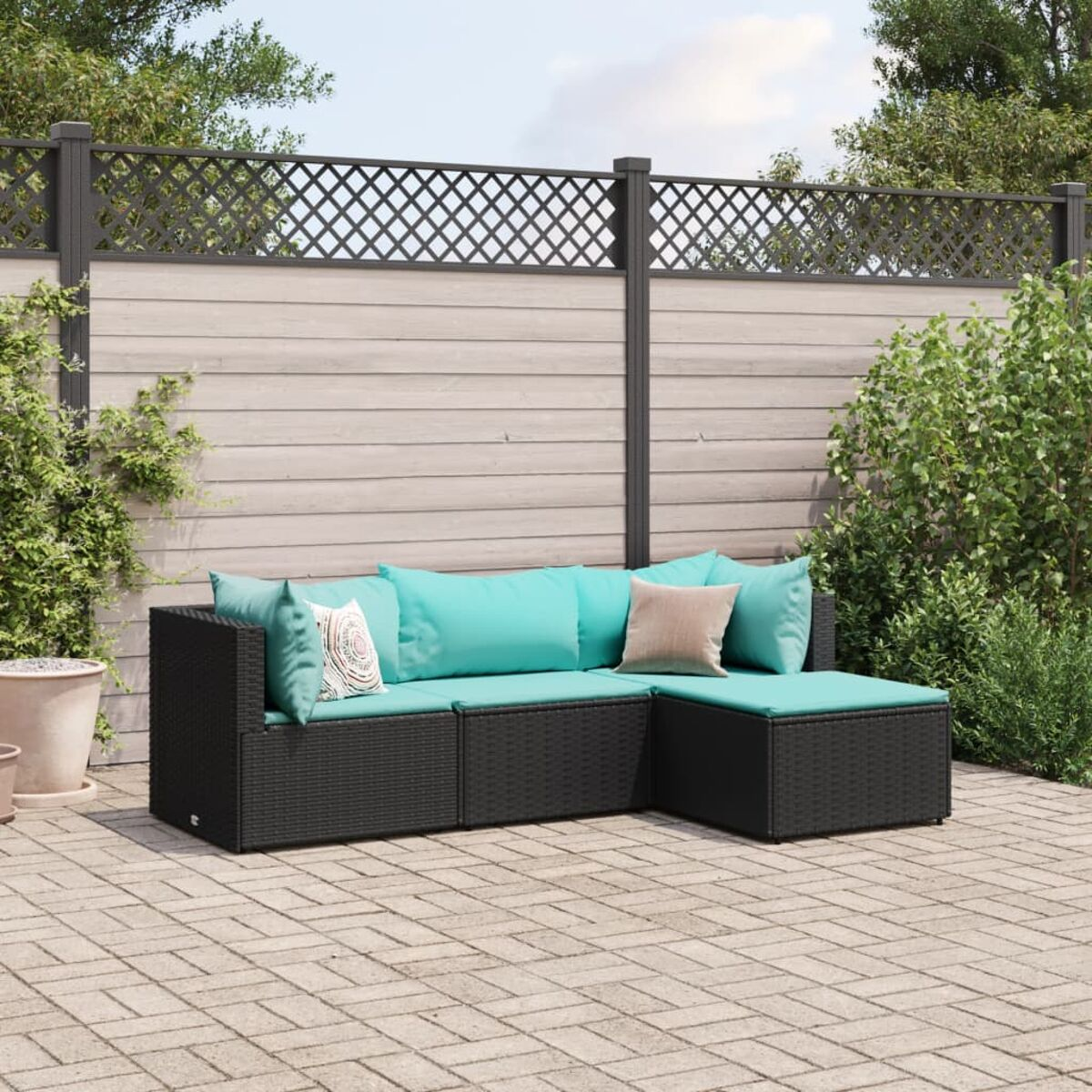 Divano angolare in rattan nero. Include angolo, pouf e cuscini. Ambientazione patio.