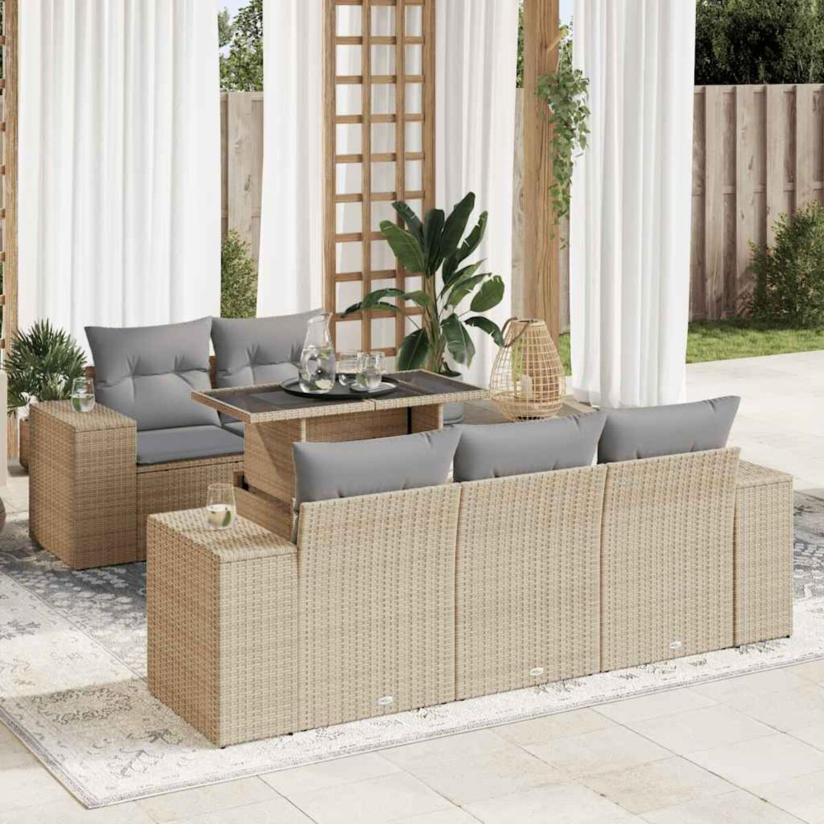 Set di mobili da esterno in vimini con cuscini, tavolo e decorazioni.