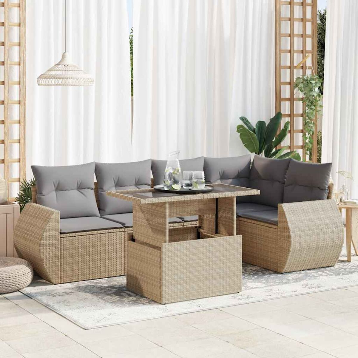 Set patio in vimini beige con tavolo in vetro e cuscini grigi.