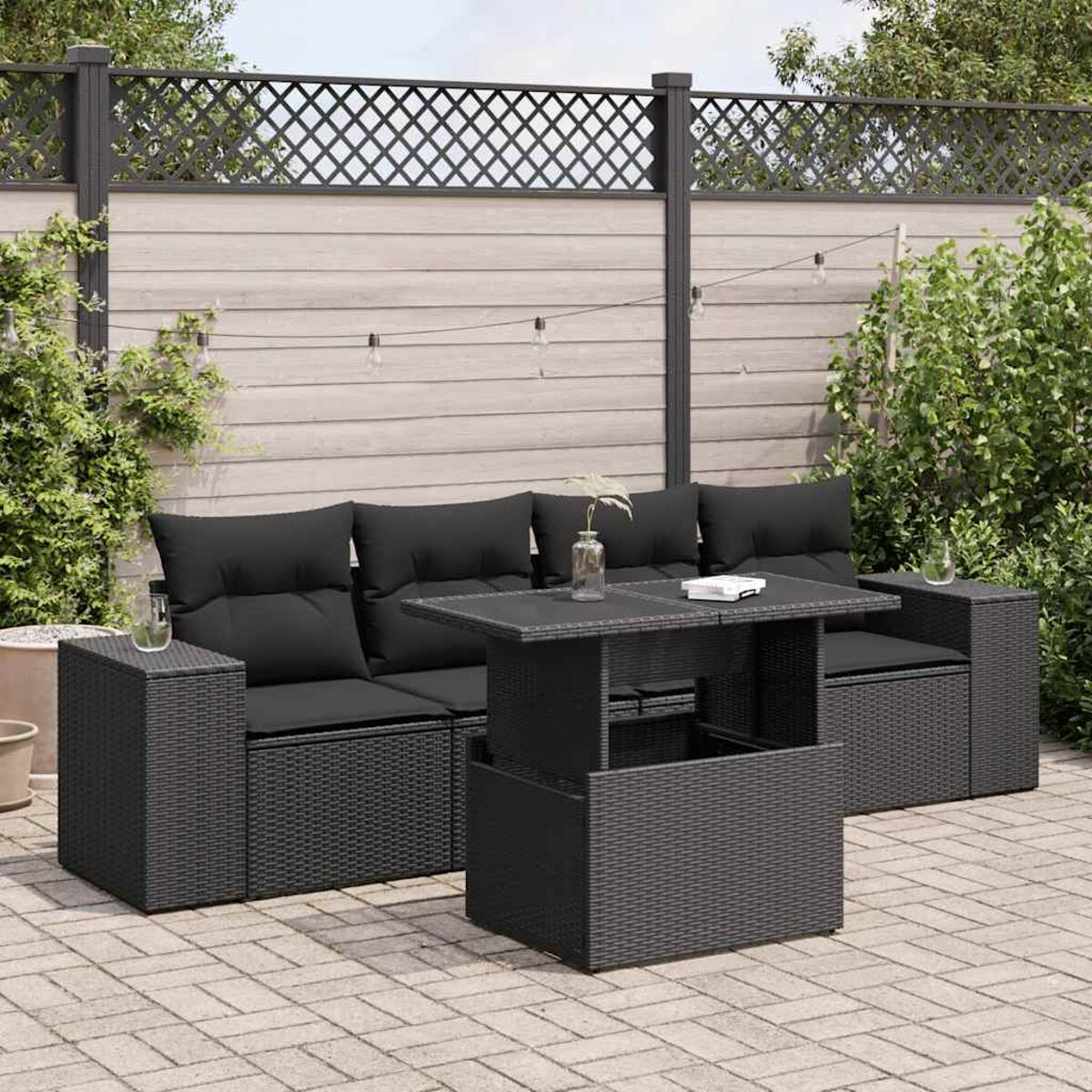 Set di sedute per esterni nero. Include divano, sedie e un tavolo. Sul patio, con sfondo.
