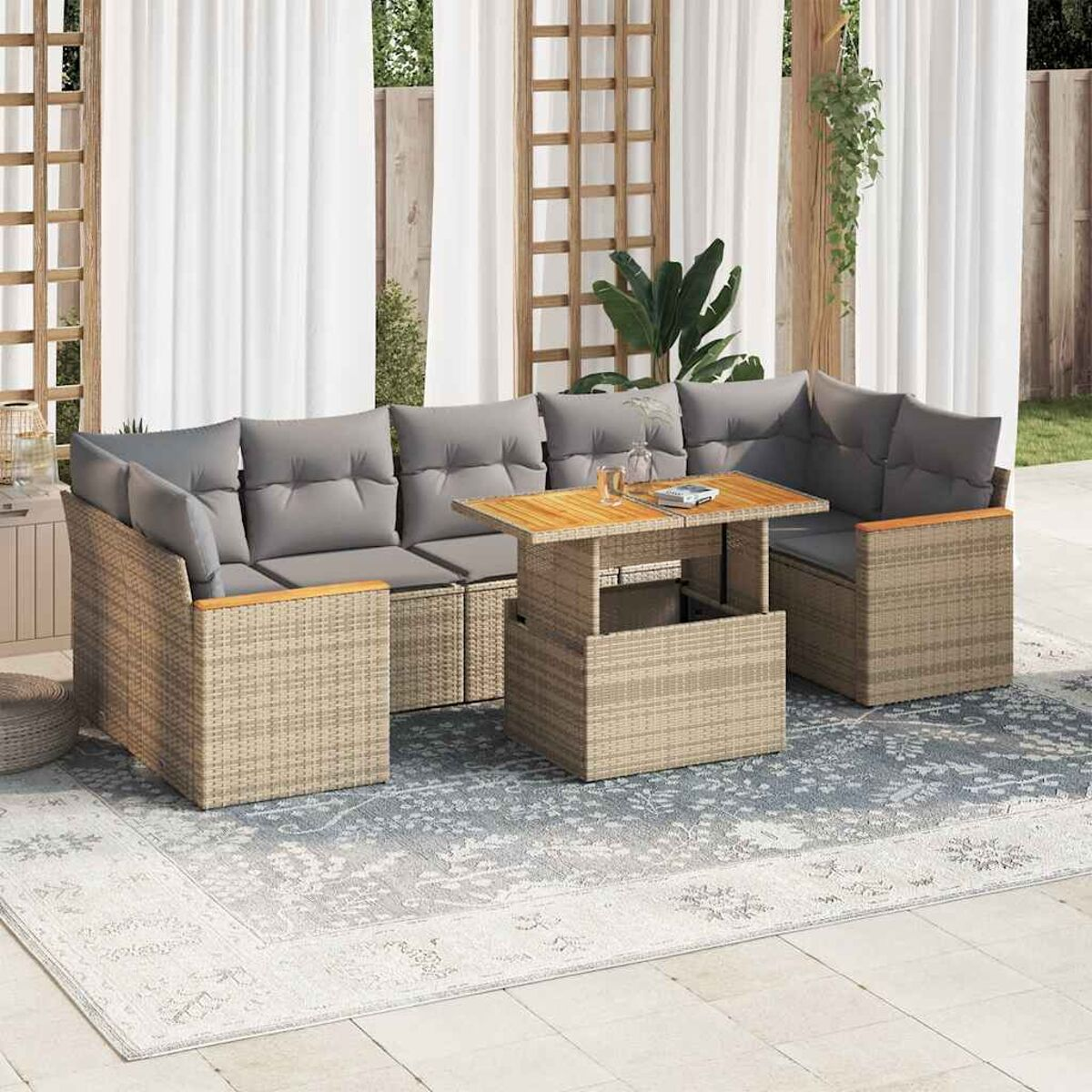 Rattan-Sofagarnitur mit Hebetisch, Kissen und einem Teppich. Szene auf einer Terrasse.
