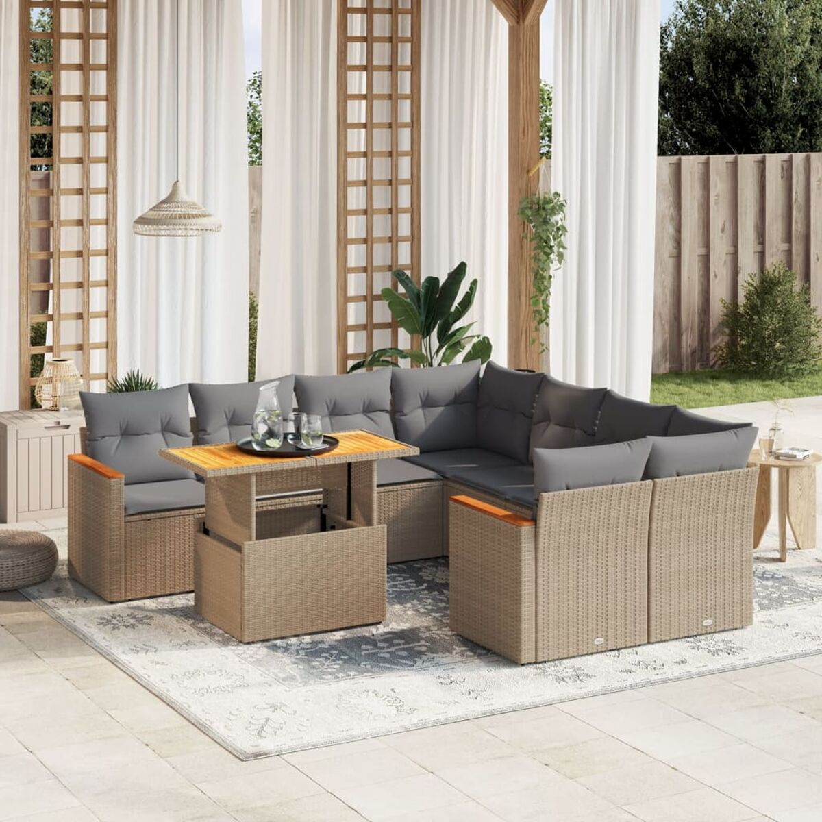 Beiges Outdoor-Ecksofa mit grauen Kissen und einem Holztisch. Vorhänge und Pflanzen sichtbar.